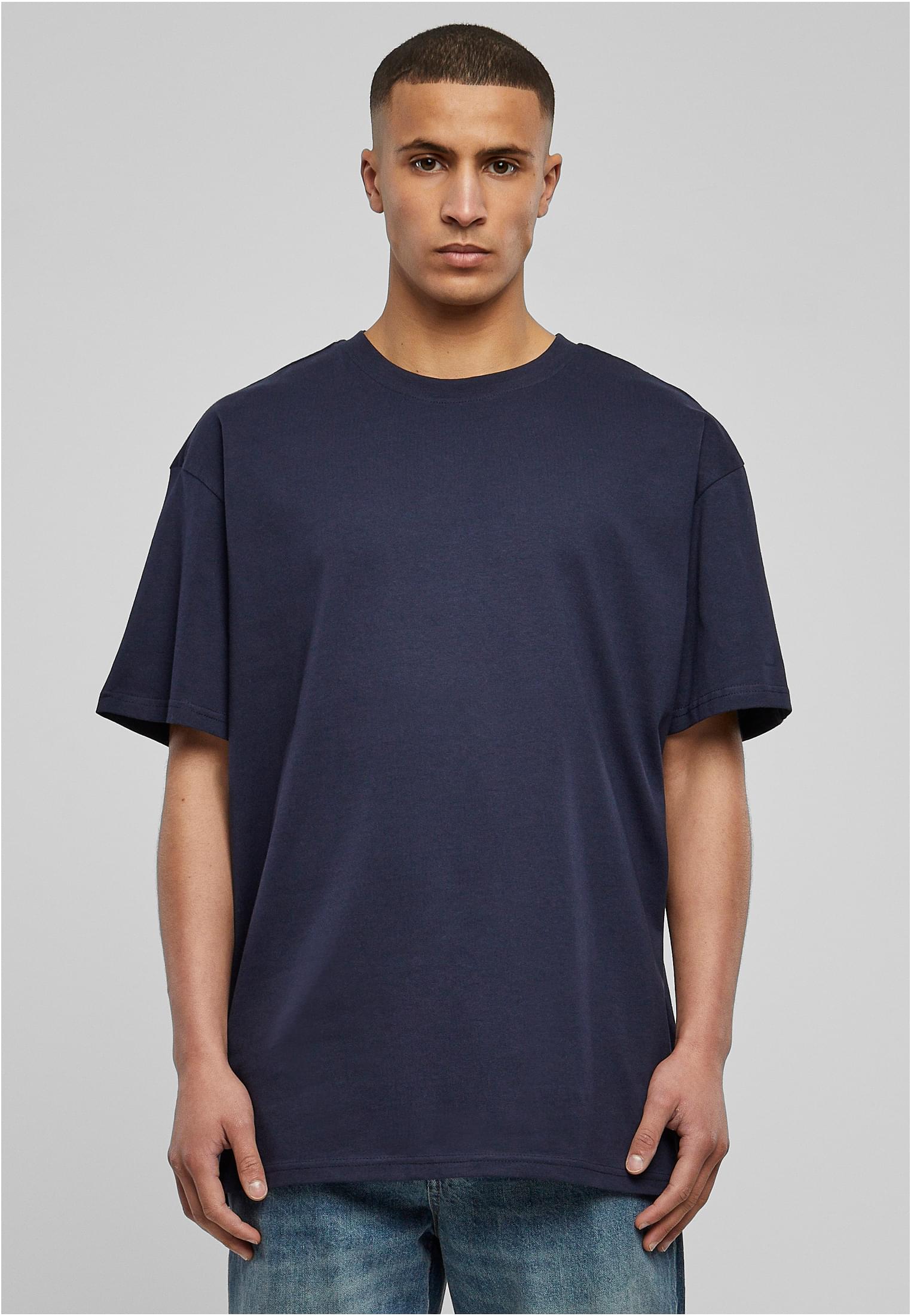 Manlig modell som bär en mörkblå Heavy Oversized Tee från Urban Classics.
