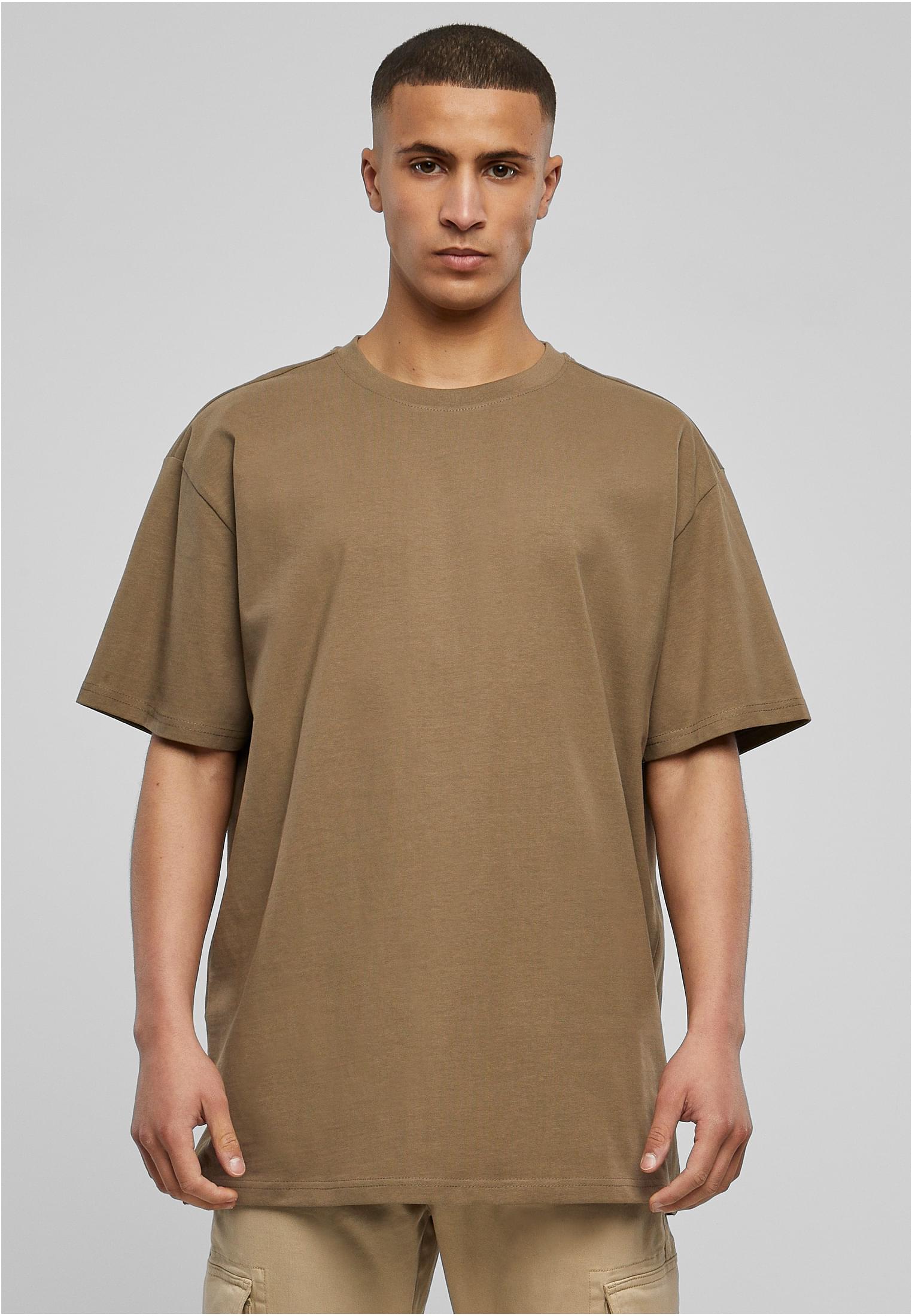 Manlig modell som bär en ljusbrun oversized t-shirt från Urban Classics.