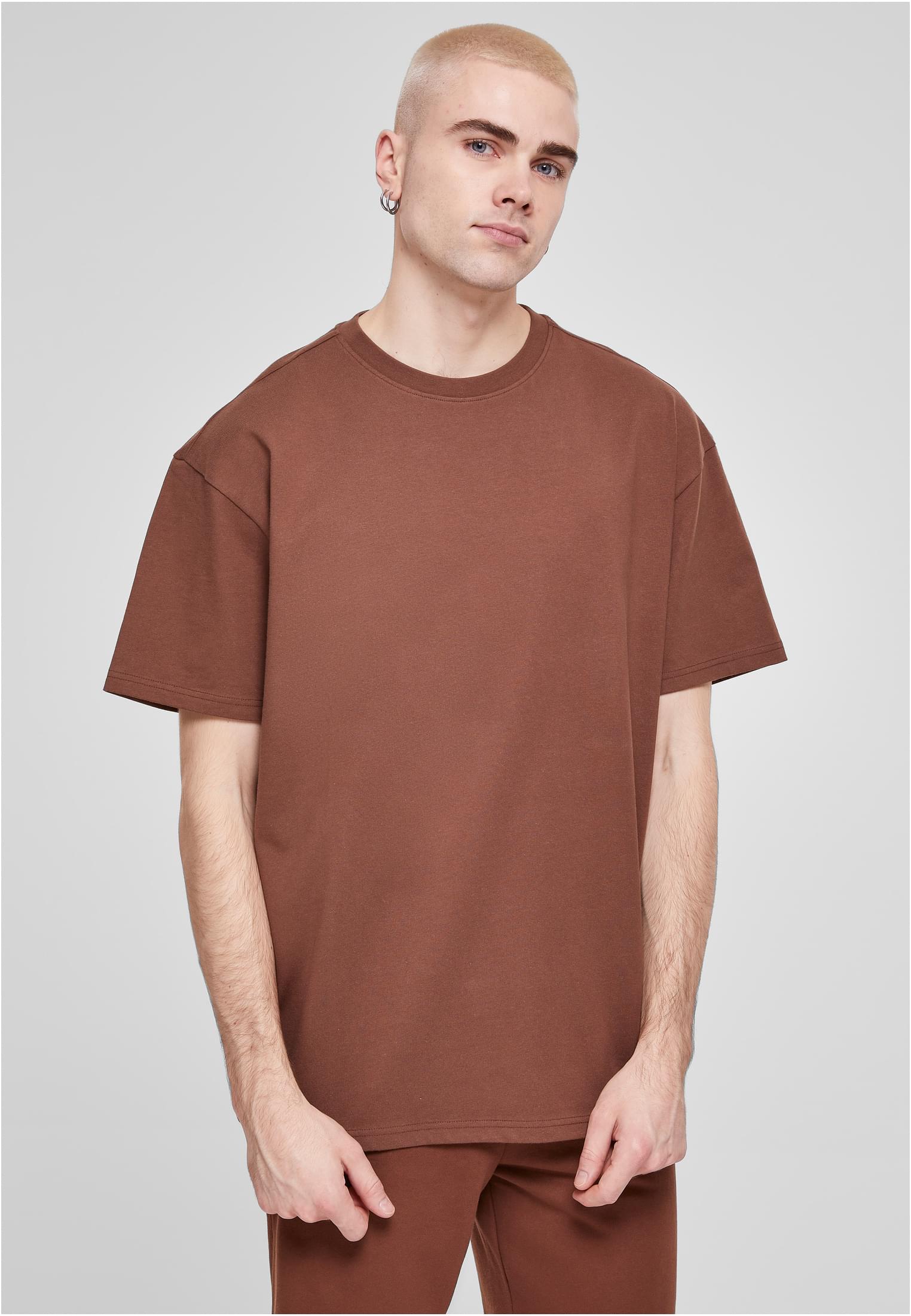 En manlig modell visar framsidan av en brun UC Heavy Oversized Tee.