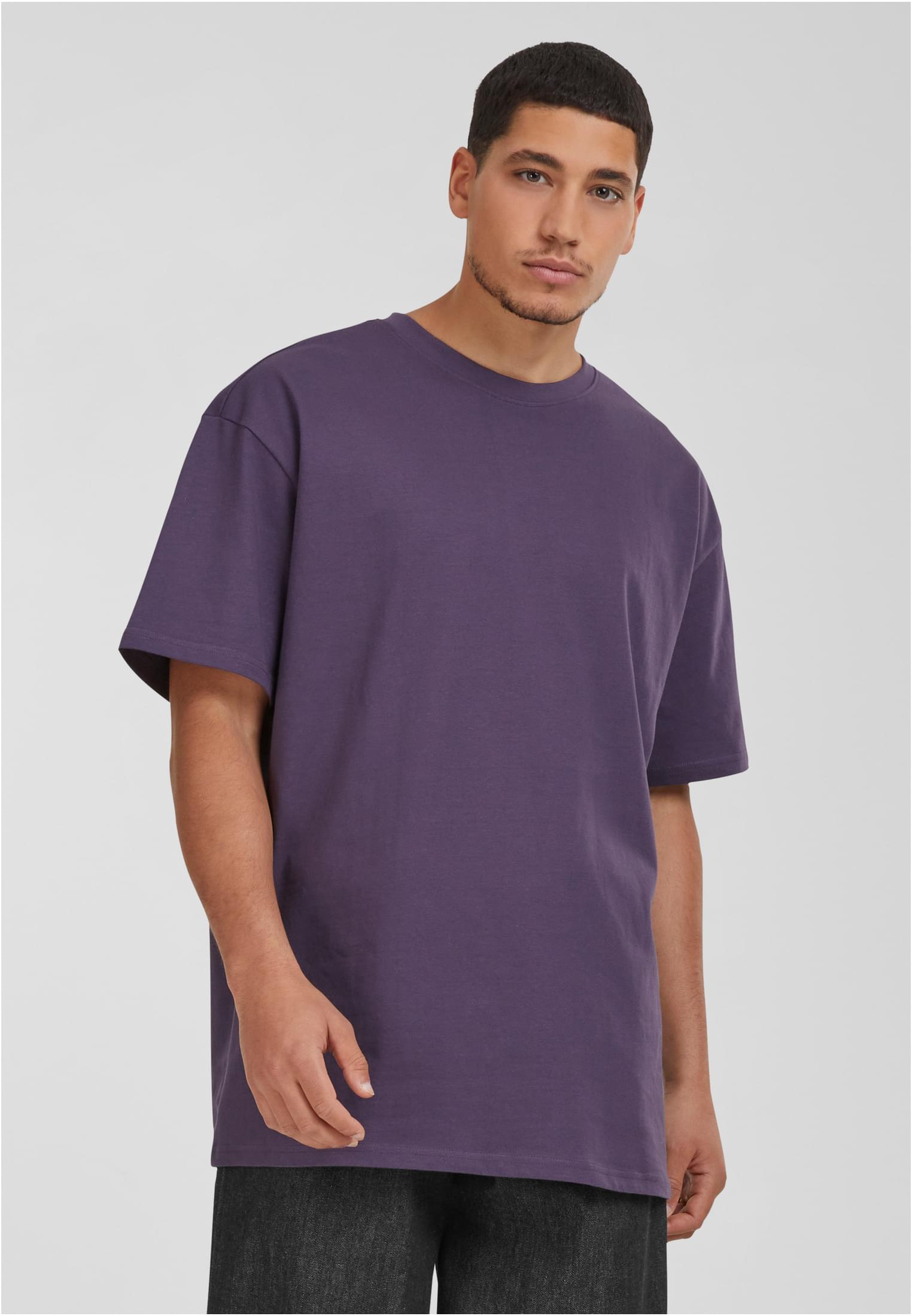 En man som bär en lila Heavy Oversized T-shirt.