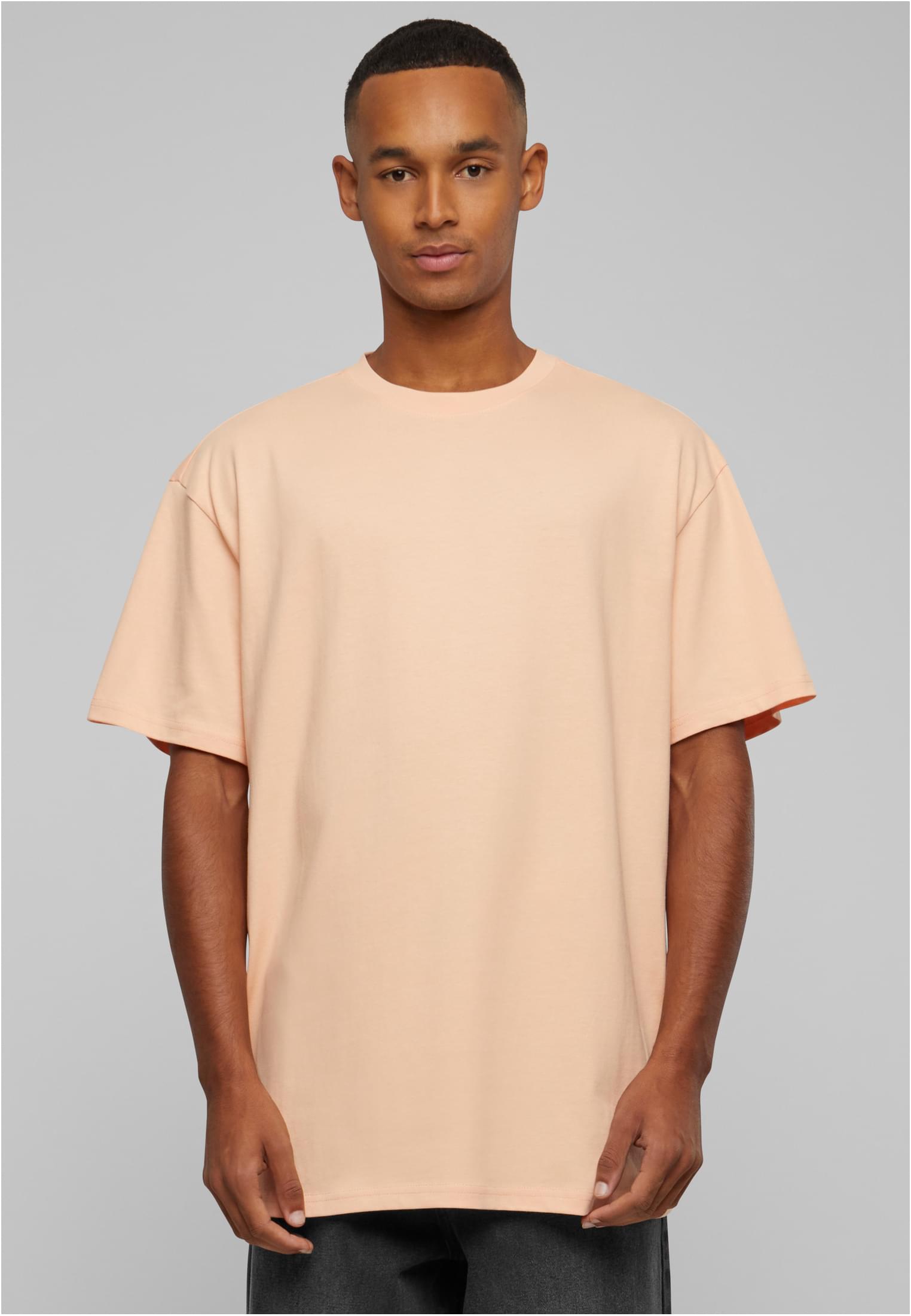 En man i en ljus persikofärgad Heavy Oversized Tee, sedd framifrån.