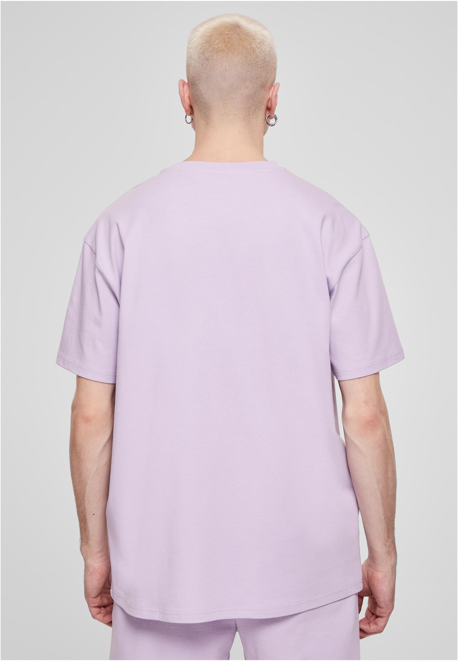 Manlig modell sedd bakifrån, bärandes en ljuslila Heavy Oversized Tee.