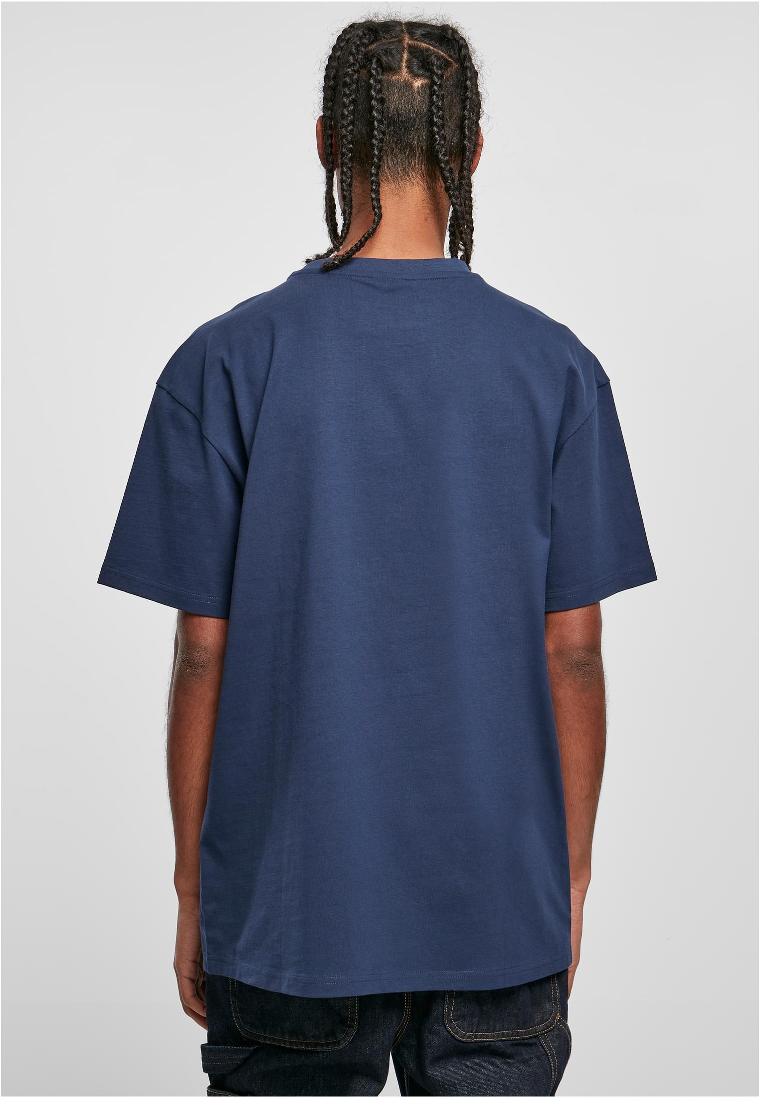 Baksidan av en man som bär en mörkblå Heavy Oversized Tee.