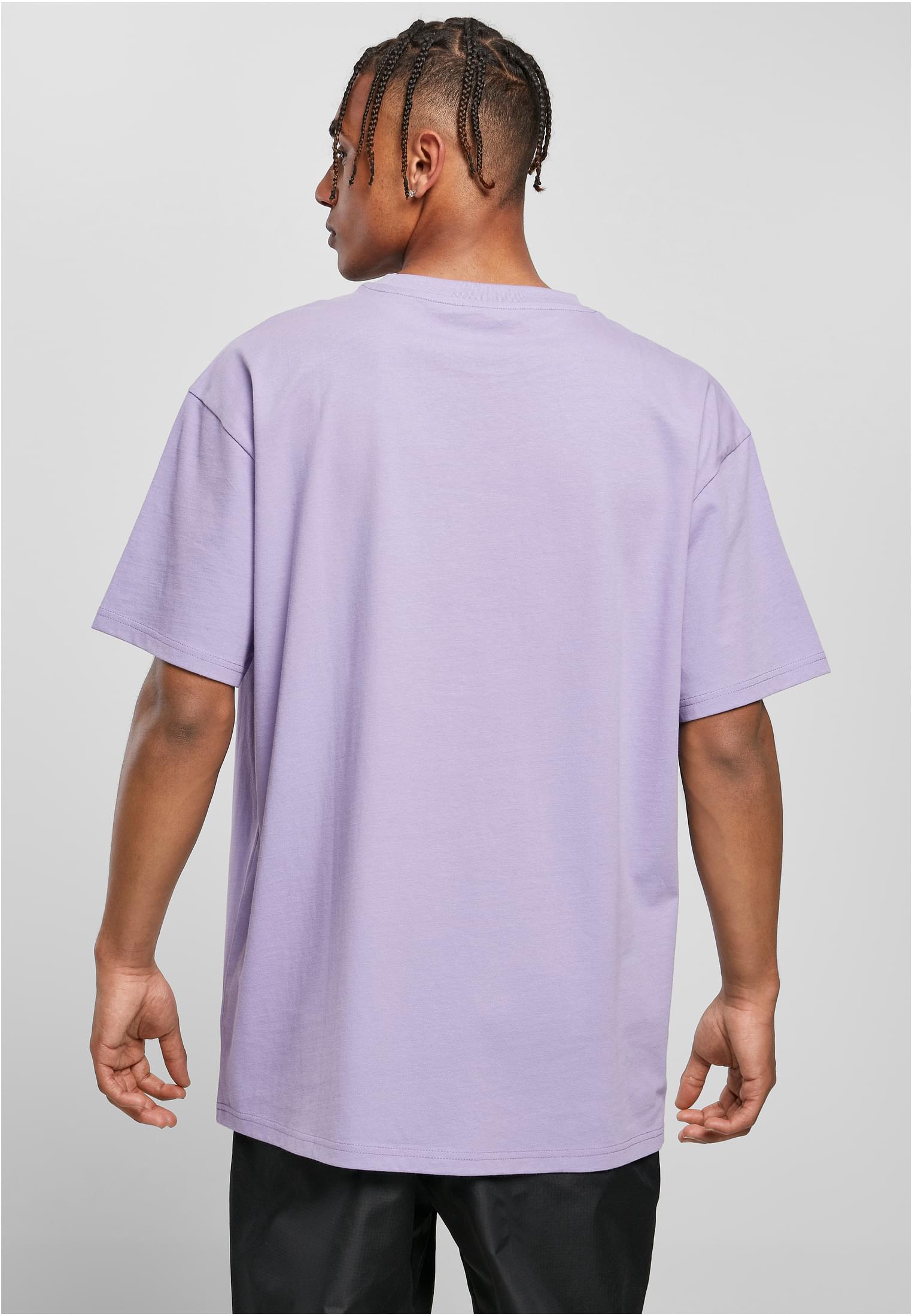 En man sedd bakifrån som bär en ljuslila Heavy Oversized Tee.