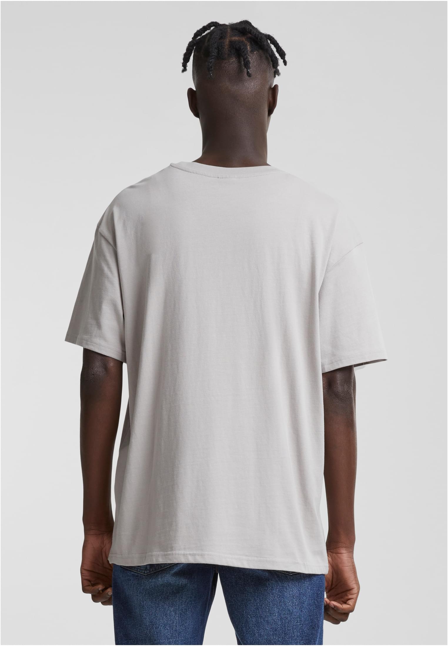 En manlig modell, fotograferad bakifrån, bär en Heavy Oversized Tee i färgen frostmint.