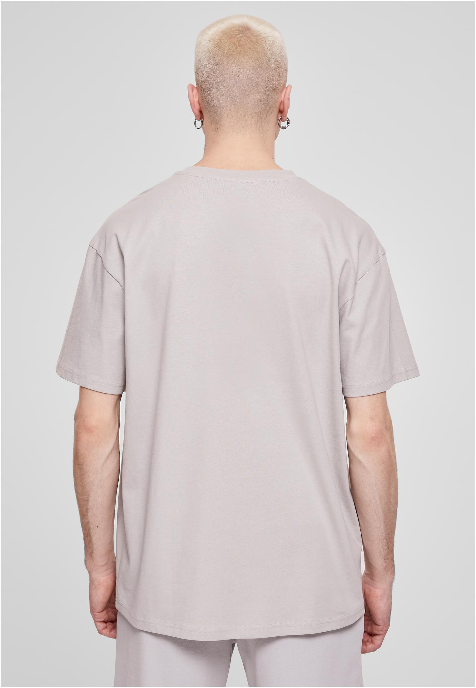 Baksidan av en manlig modell som bär en ljusgrå Heavy Oversized T-shirt.