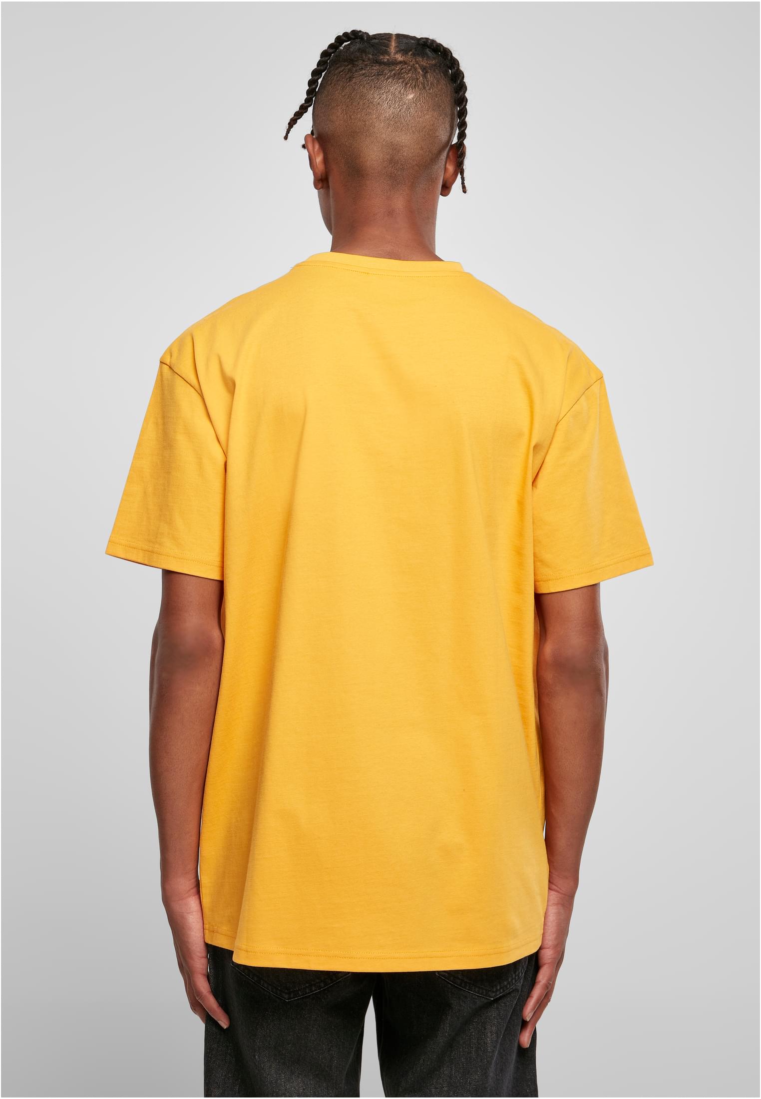 Man fotograferad bakifrån i en gul Heavy Oversized Tee.