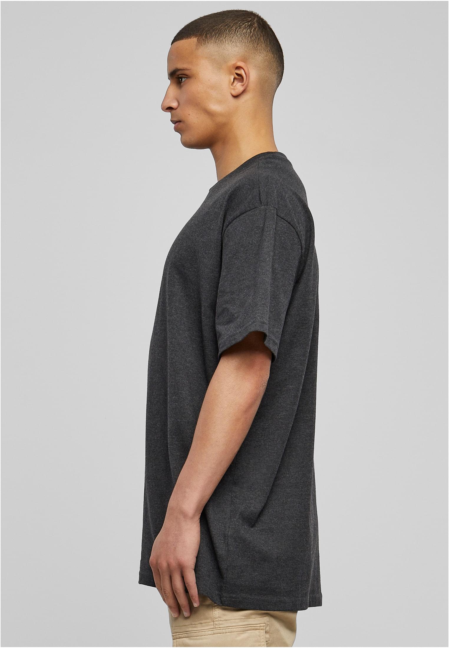 En manlig modell sedd från sidan, som bär en Heavy Oversized Tee från Urban Classics för att visa dess överdimensionerade passform.