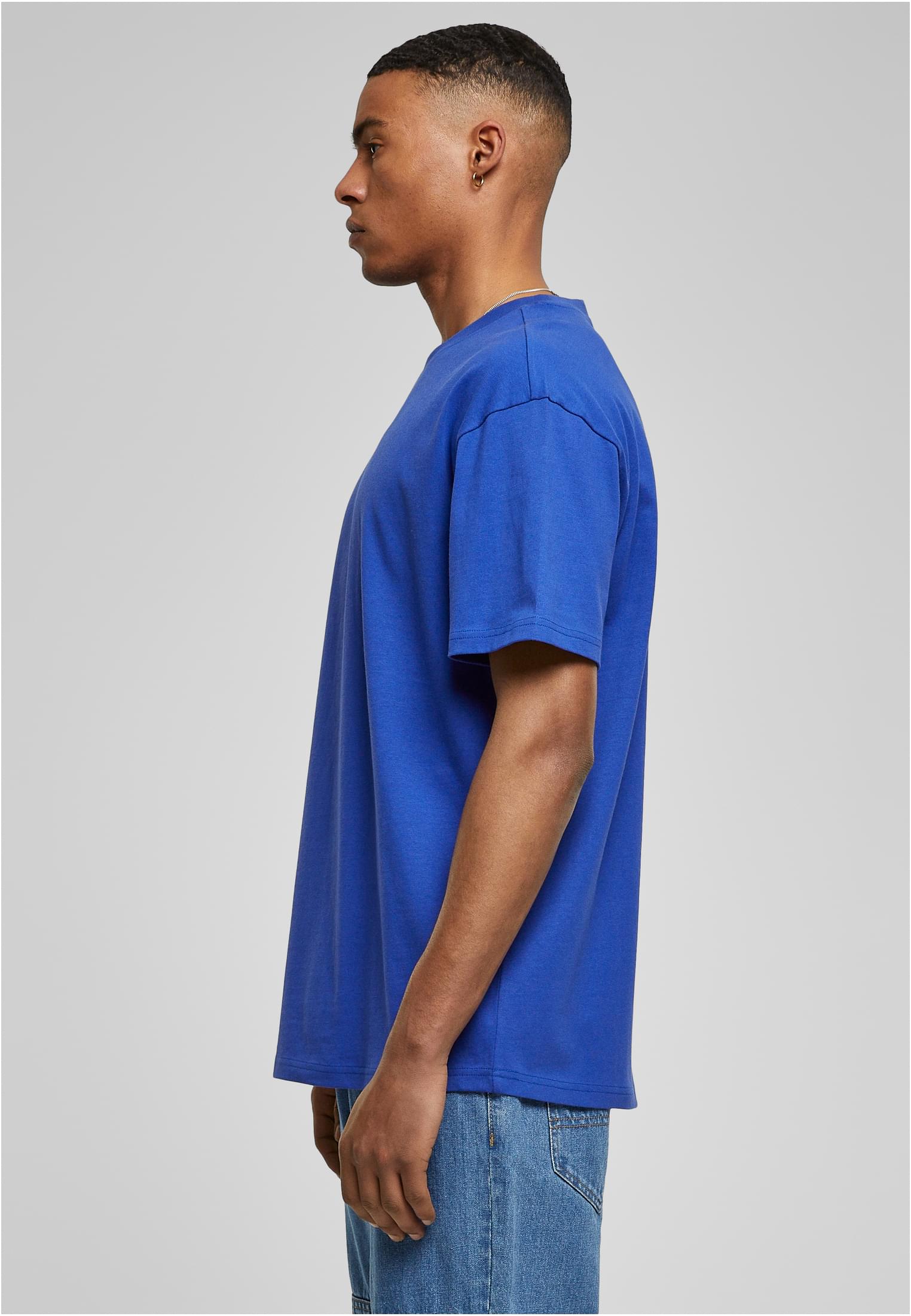 Sidovy av en man som bär en blå Urban Classics Heavy Oversized Tee.