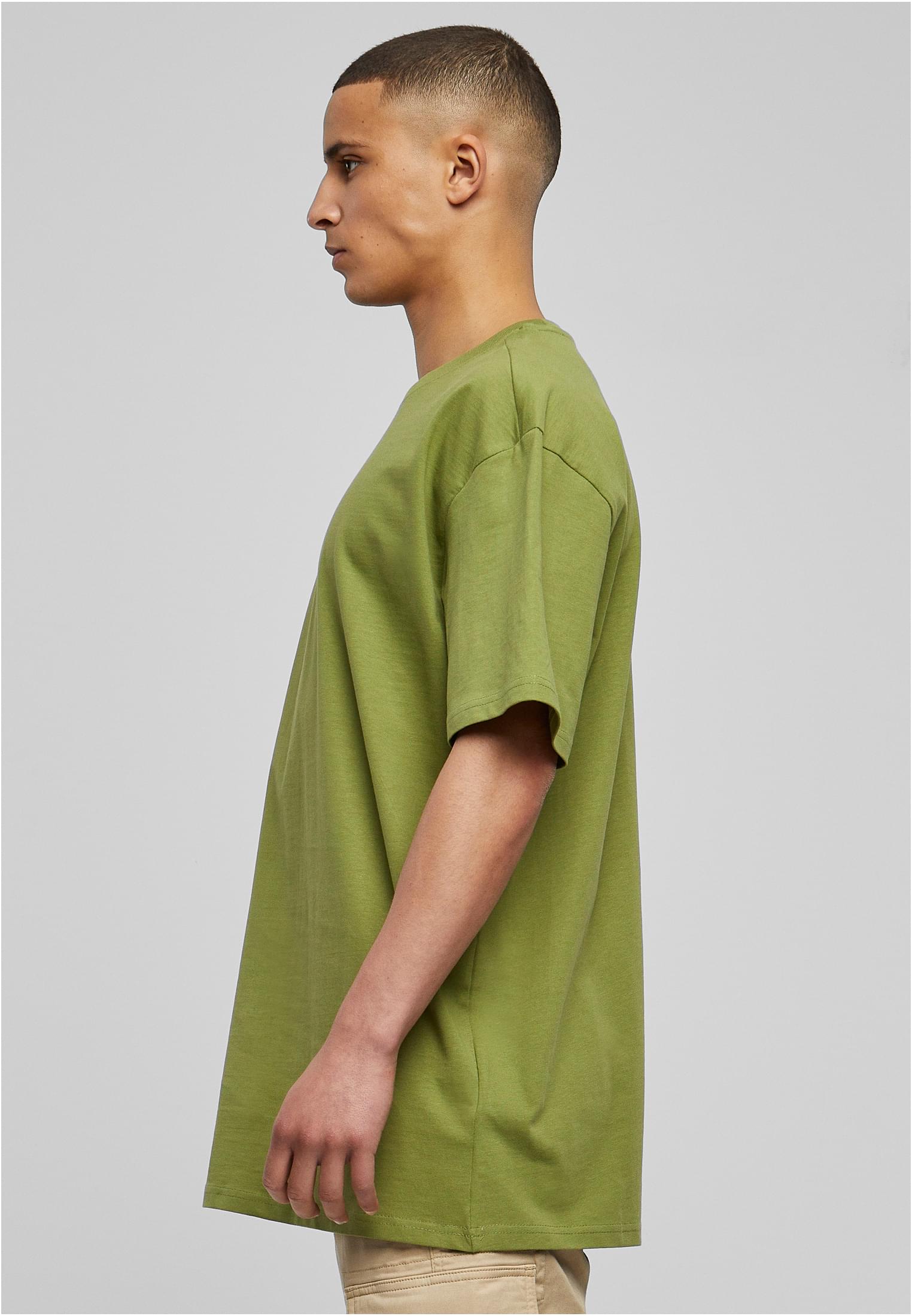 Sidoprofil av en man som bär en mintgrön Heavy Oversized Tee.