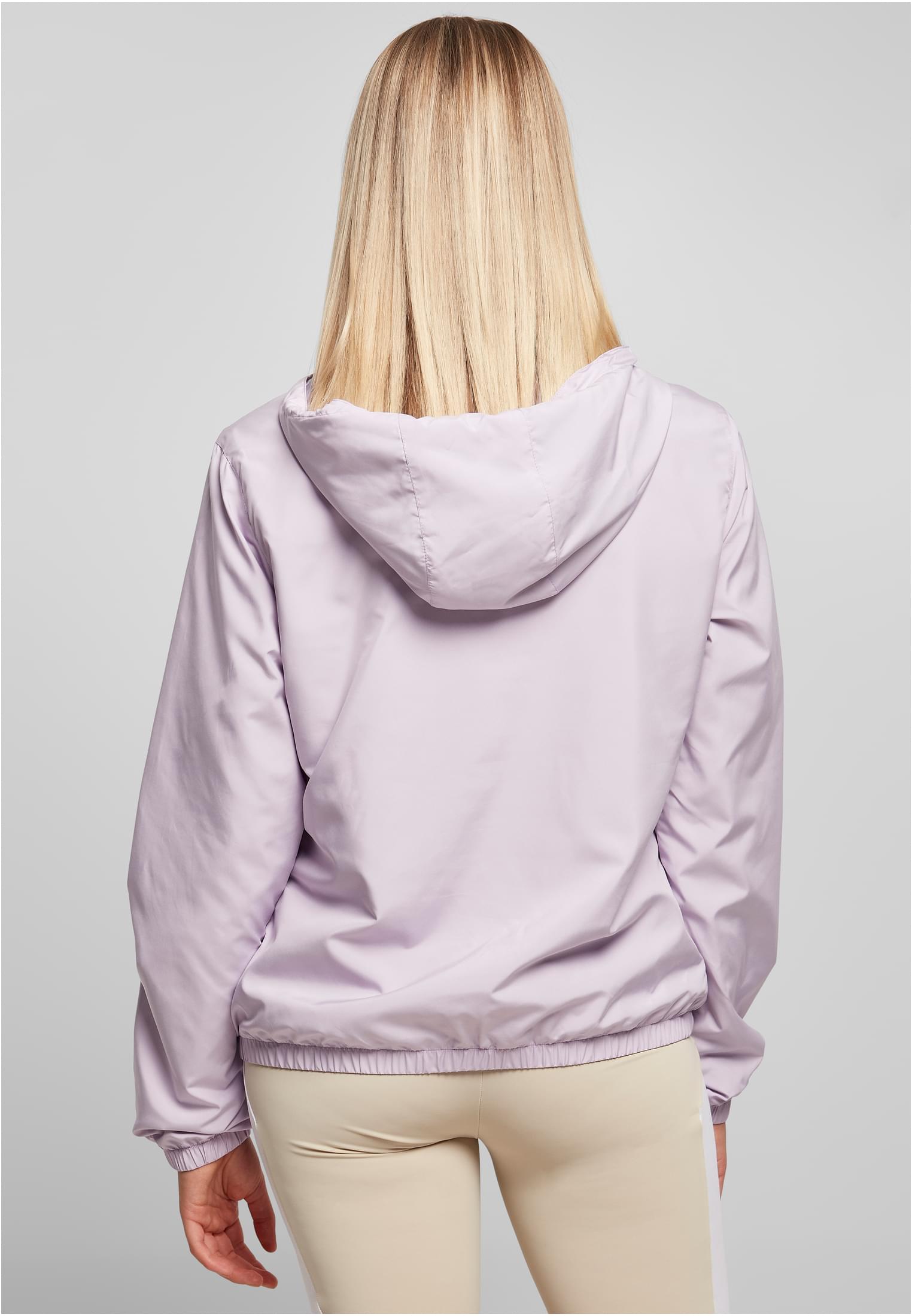 Kvinna sedd bakifrån som bär en ljuslila pull-over-jacka med huva.