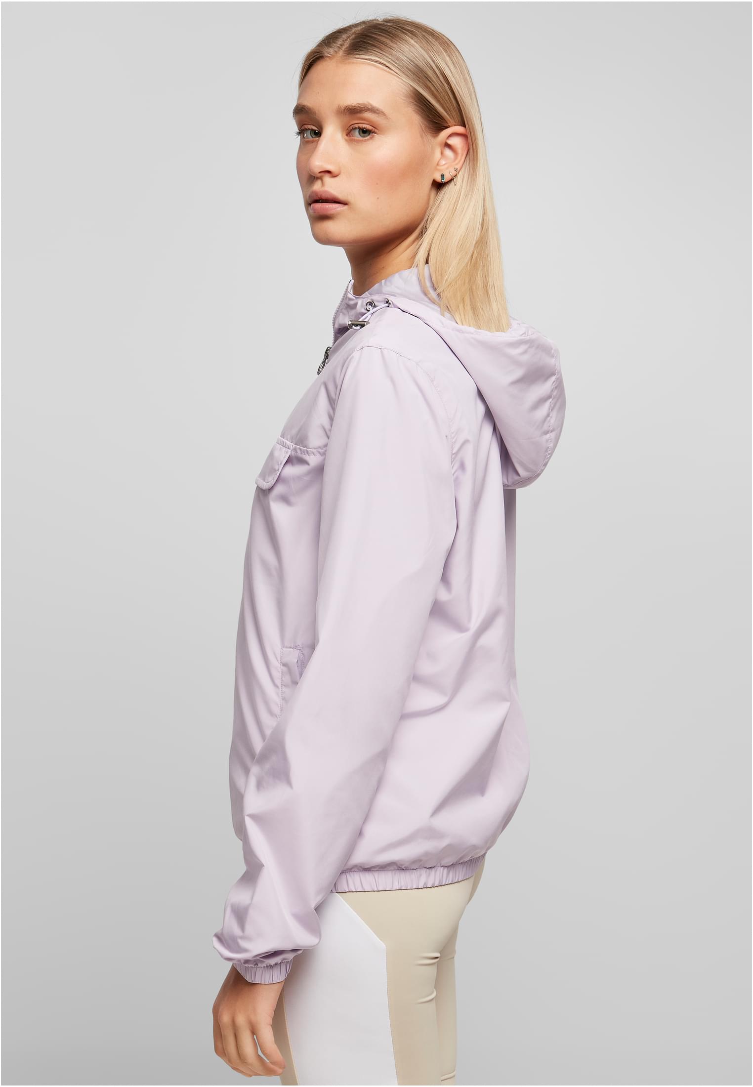 Sidoprofil av en kvinna som bär en ljuslila Ladies Basic Pull Over Jacket.