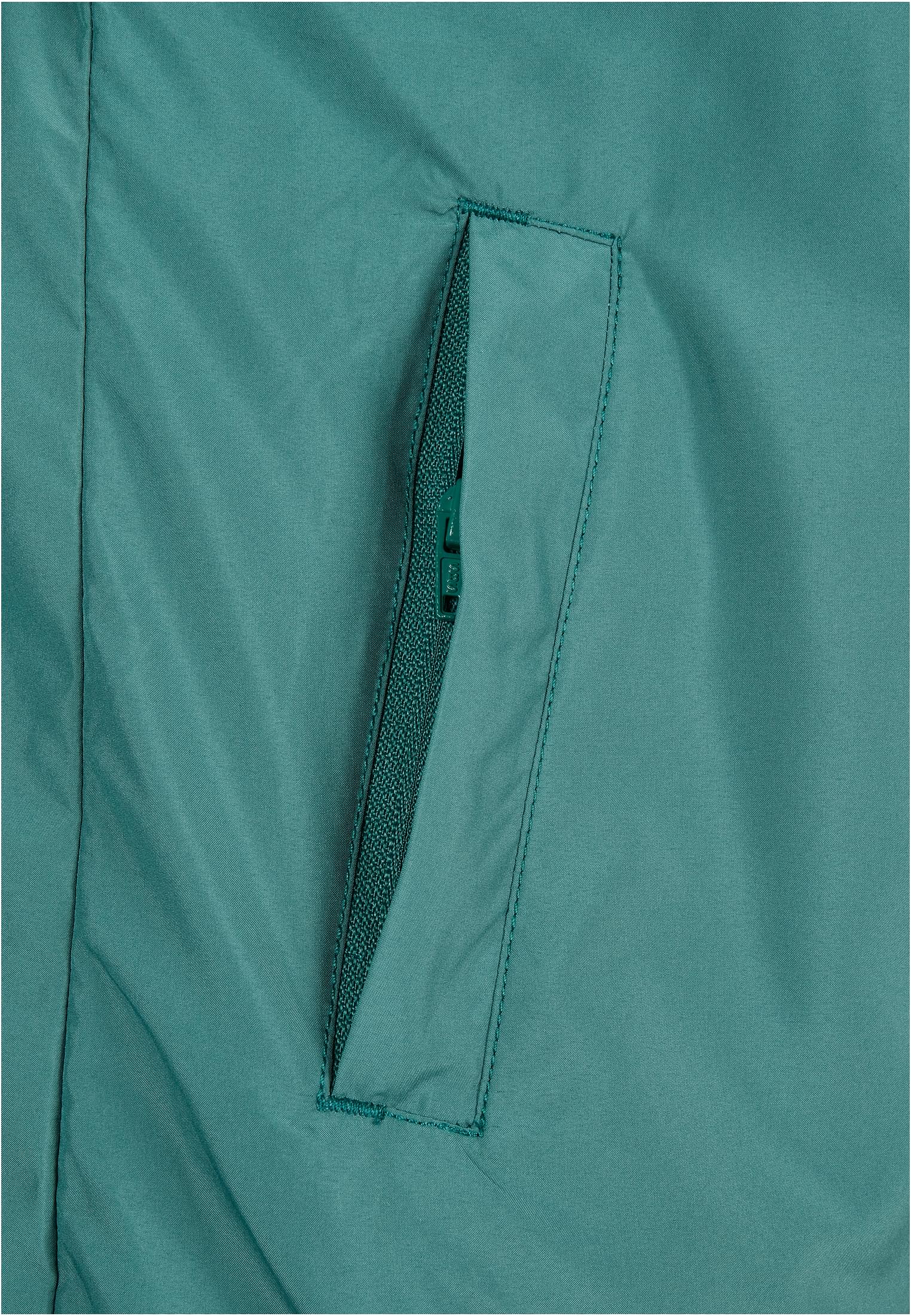Närbild på fickan med dragkedja på den vattengröna Ladies Basic Pull Over Jacket.
