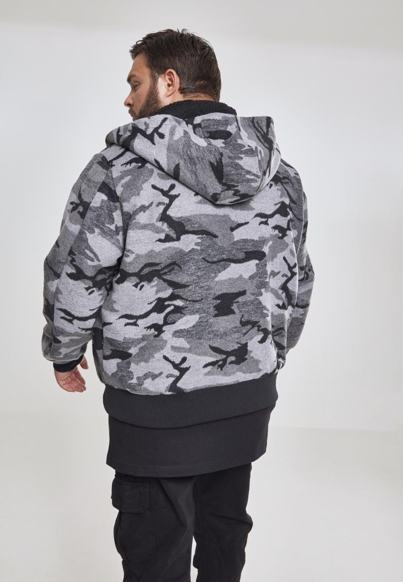 En man visar baksidan av UC Camo Zip Jacket i grått och svart kamouflagemönster.