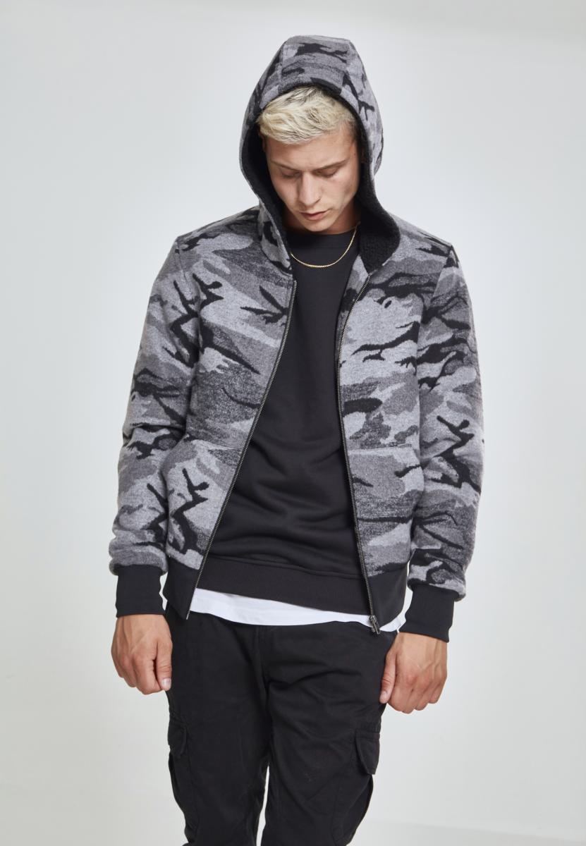 En man visar framsidan av UC Camo Zip Jacket i grått kamouflagemönster, med huvan uppdragen.