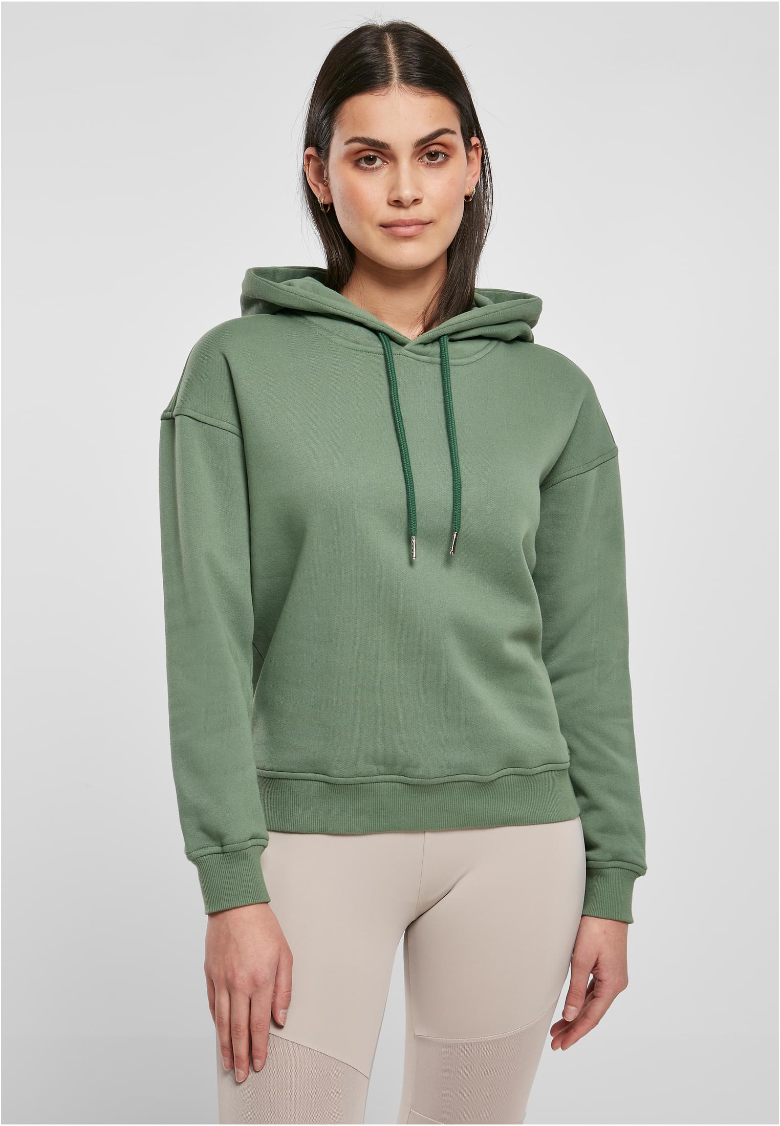 En kvinna fotograferad framifrån som bär den gröna UC Ladies Organic Hoody.
