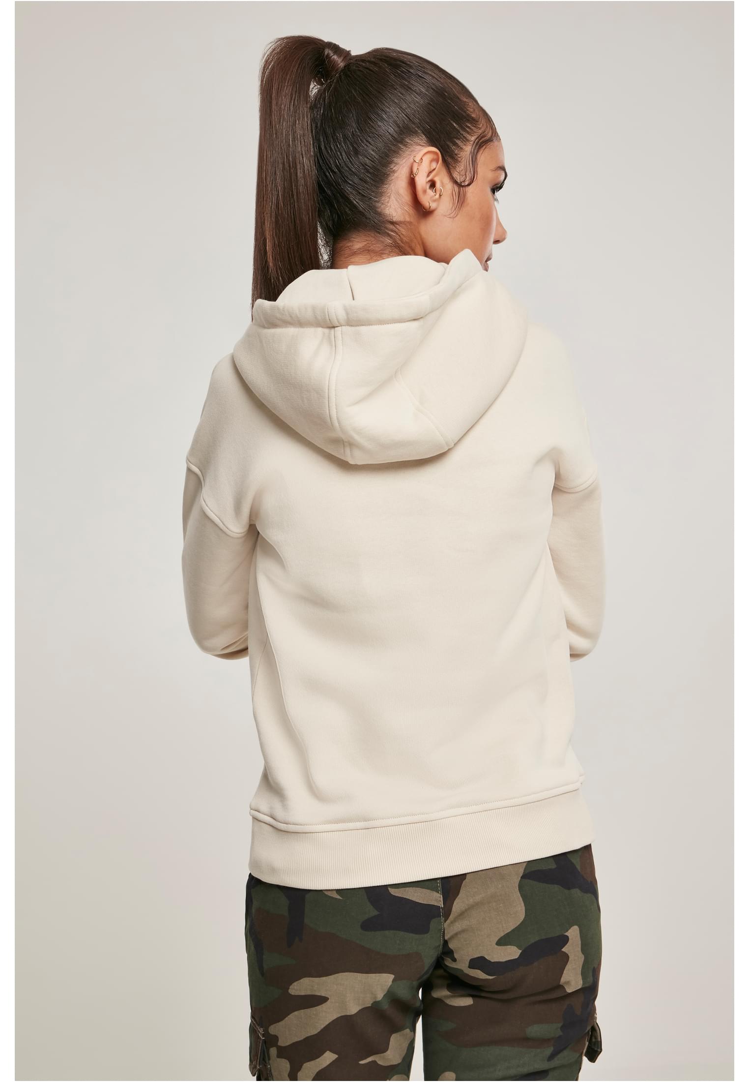 Kvinna sedd bakifrån som bär en benvit UC Ladies Organic Hoody.