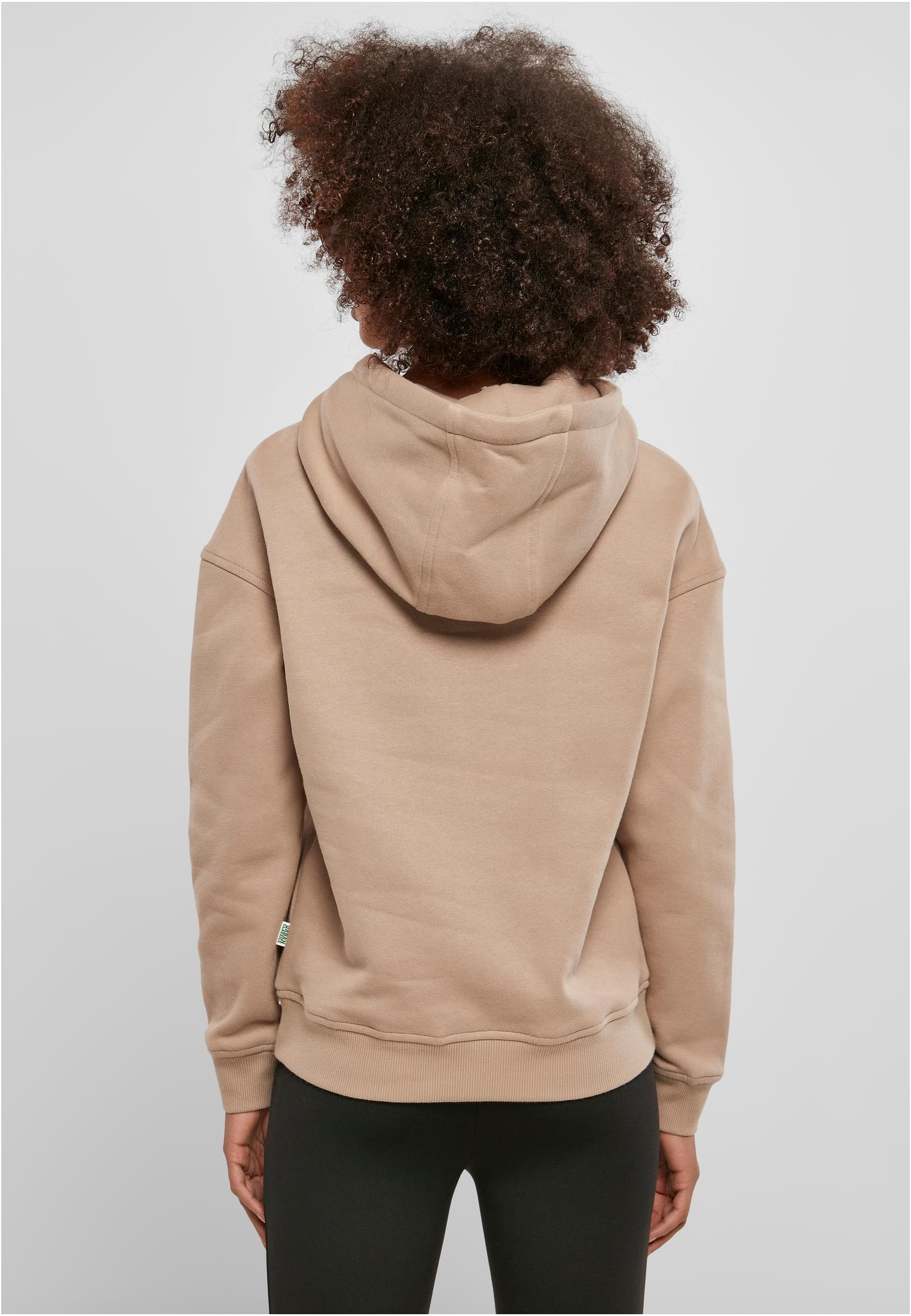 En kvinna, fotograferad bakifrån, som bär en beige UC Ladies Organic Hoody.
