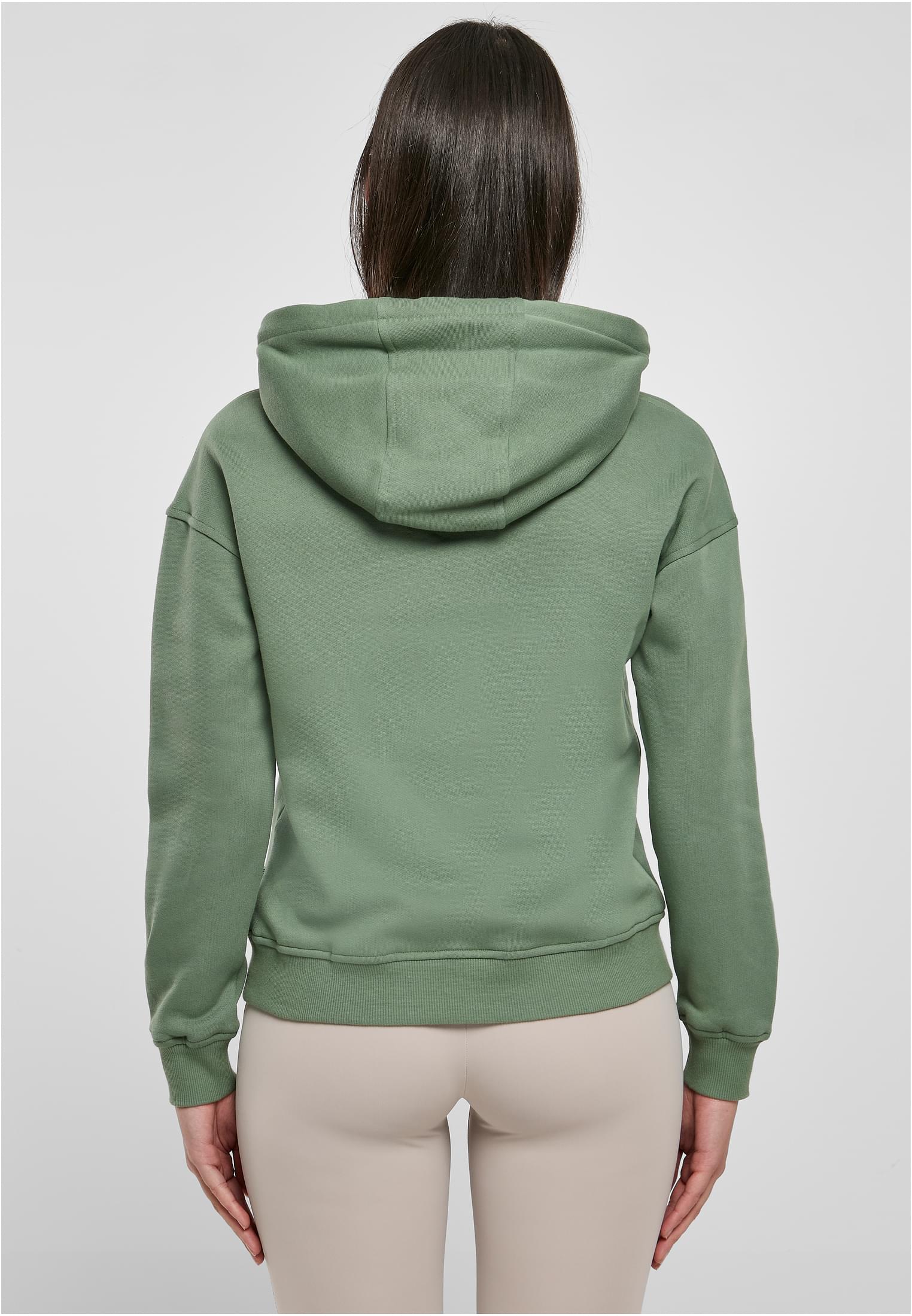 Baksidan av en kvinna som bär en grön UC Ladies Organic Hoody.