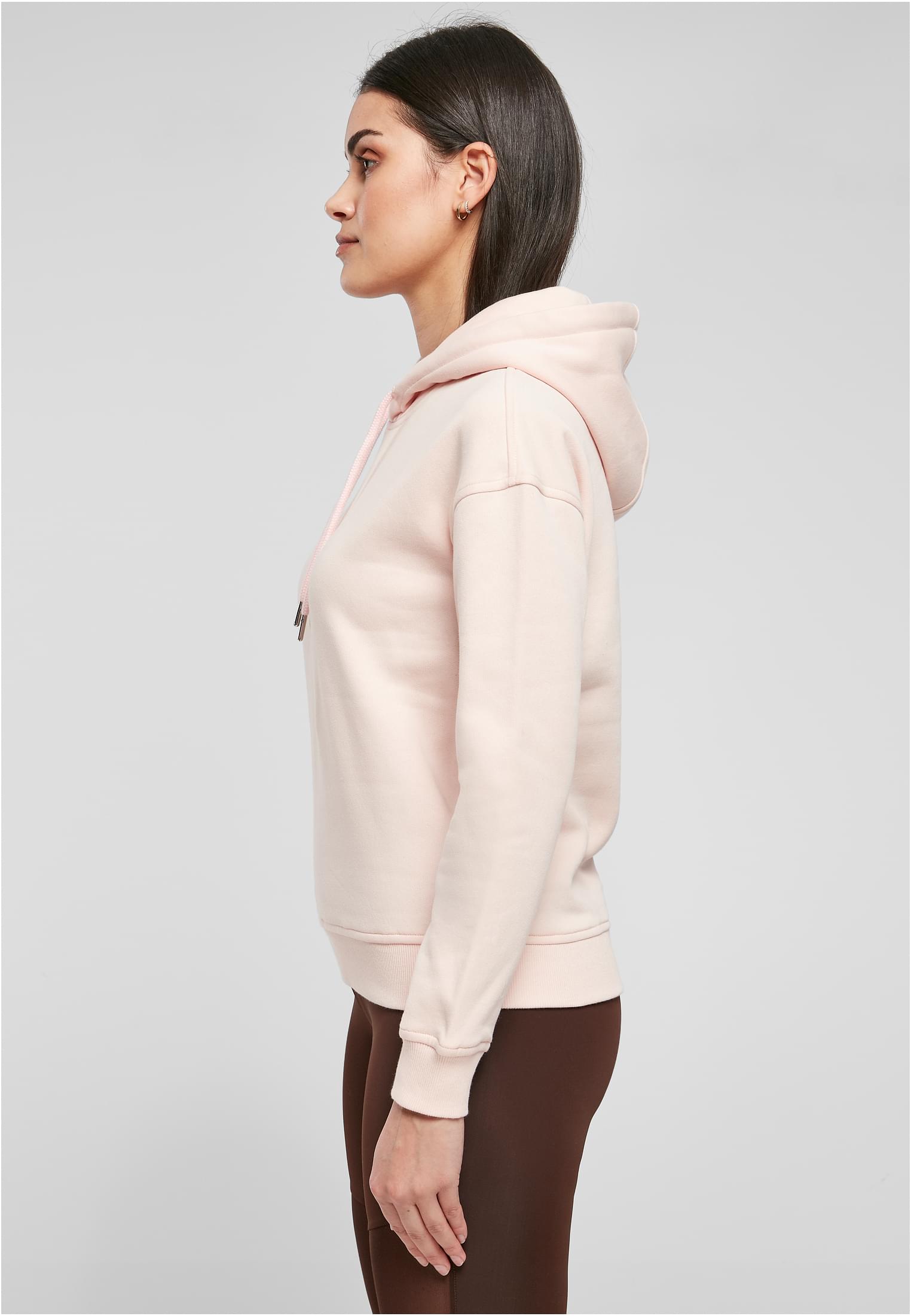 Kvinna i profil som bär en terrakottafärgad Ladies Organic Hoody.