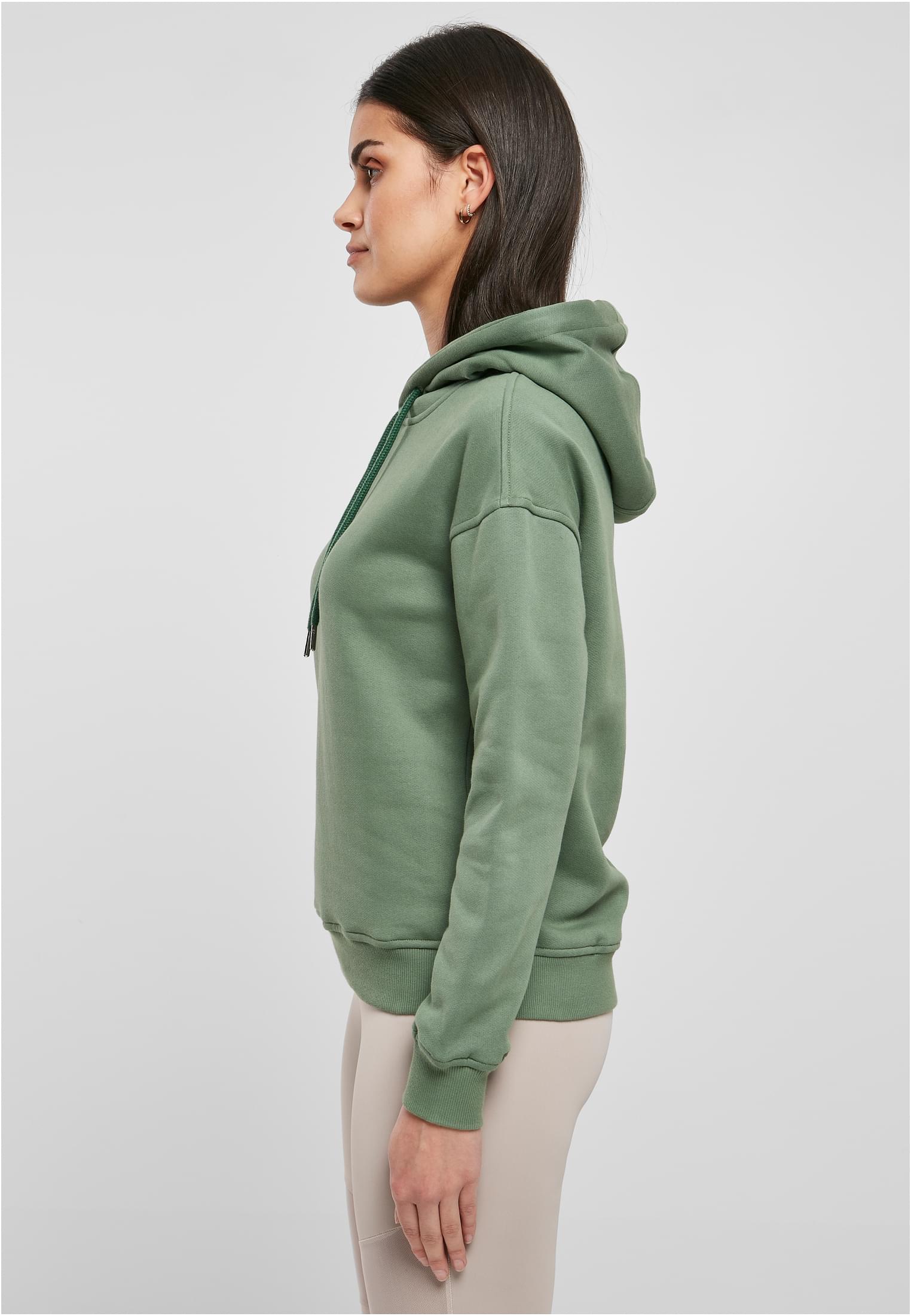 Kvinna i profil som bär den gröna UC Ladies Organic Hoody.
