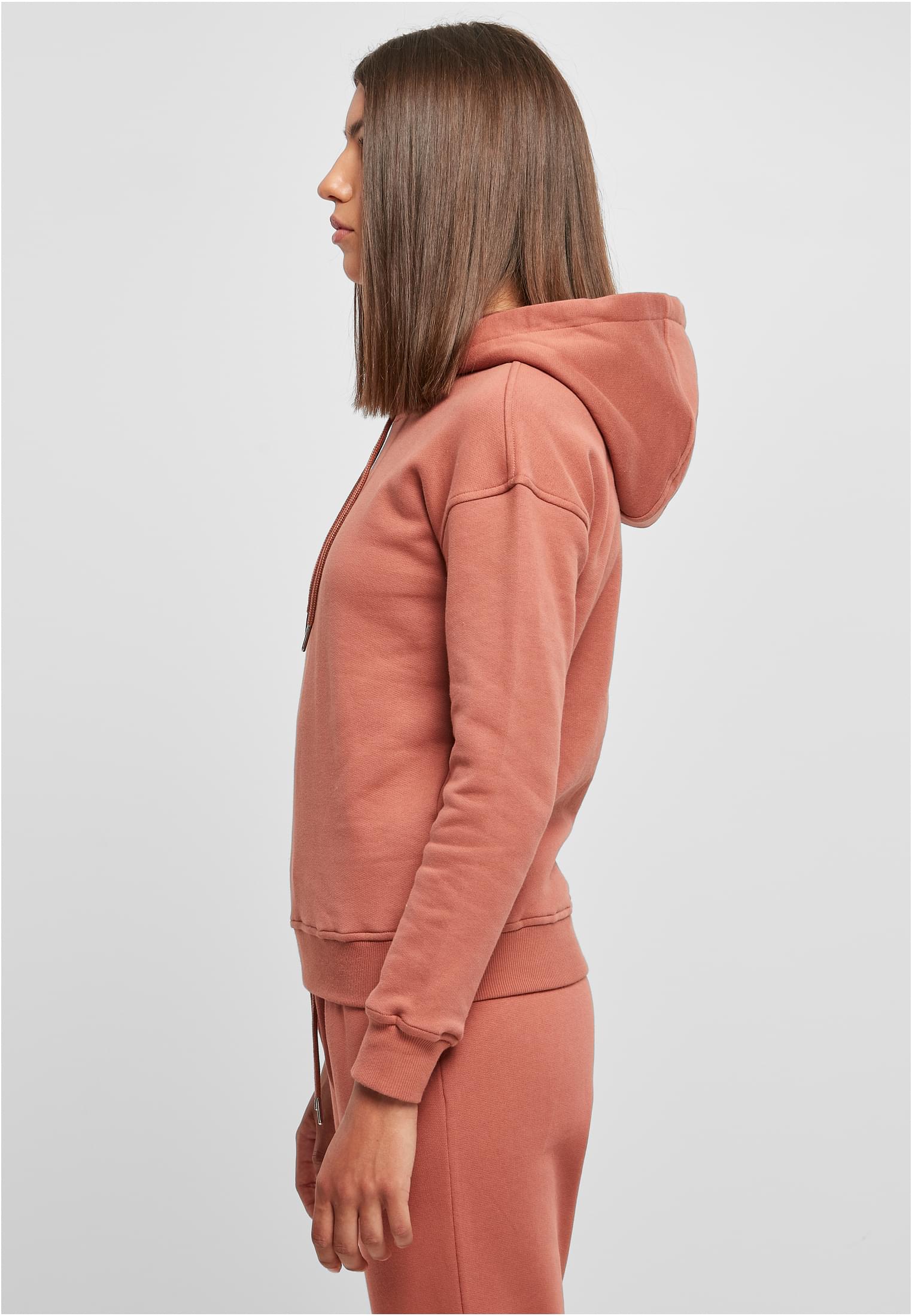 Sidovy av en kvinna som bär en rosa UC Ladies Organic Hoody och matchande byxor.