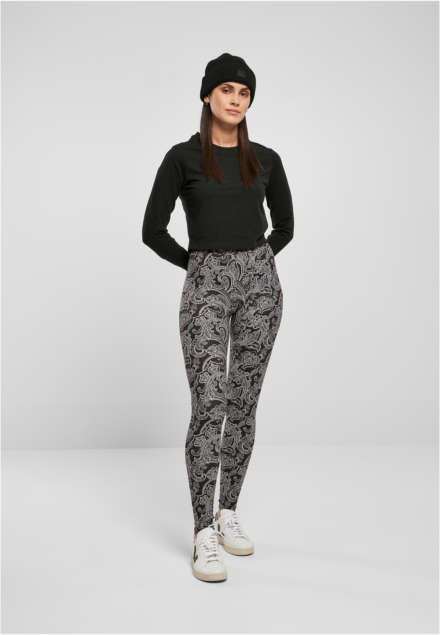Helbild på en modell som bär UC Ladies Soft AOP Leggings med svart och vitt mönster, tillsammans med en svart långärmad tröja och mössa.