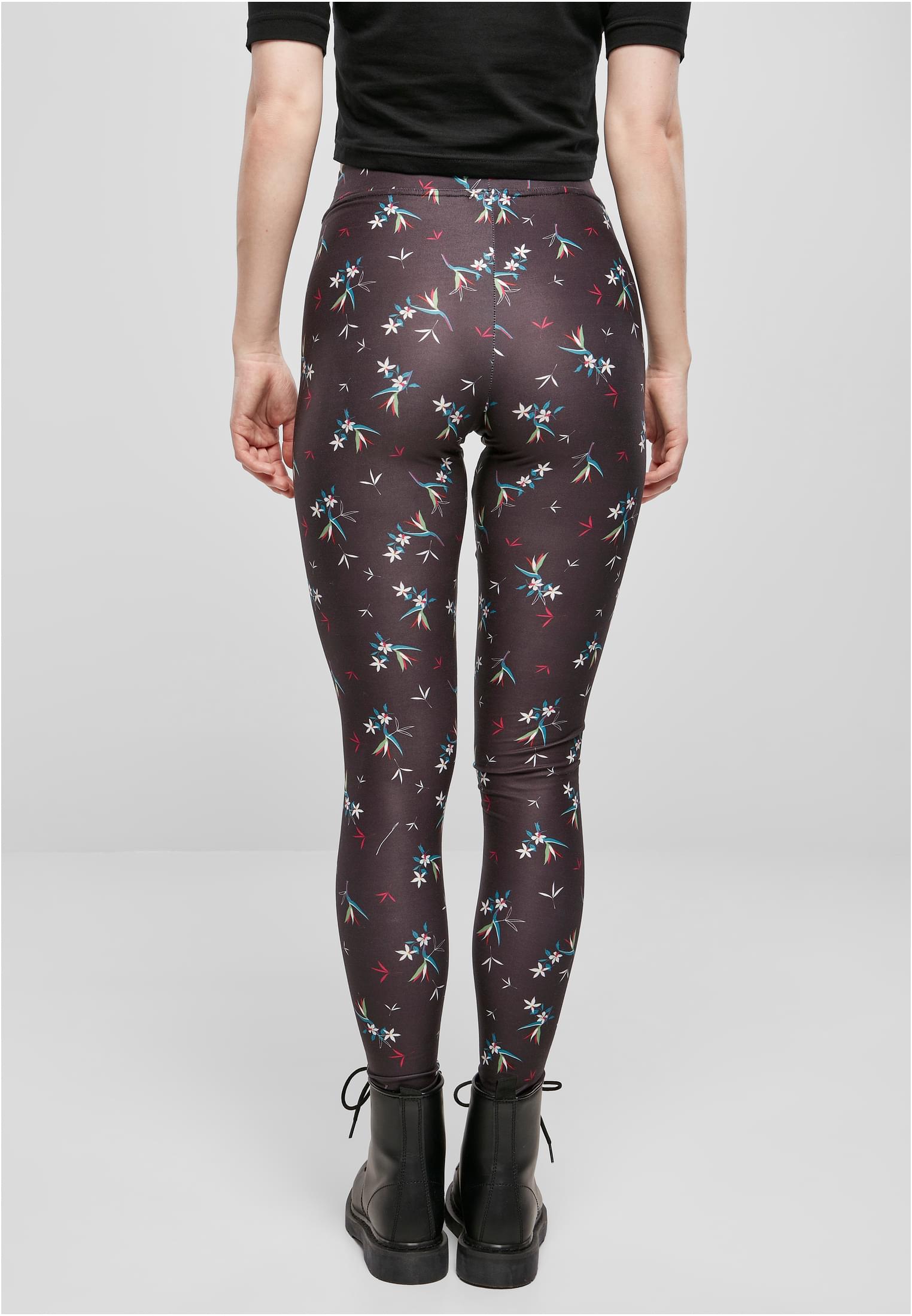 Bakifrånvy av en kvinna i svarta blommönstrade leggings och svarta kängor.