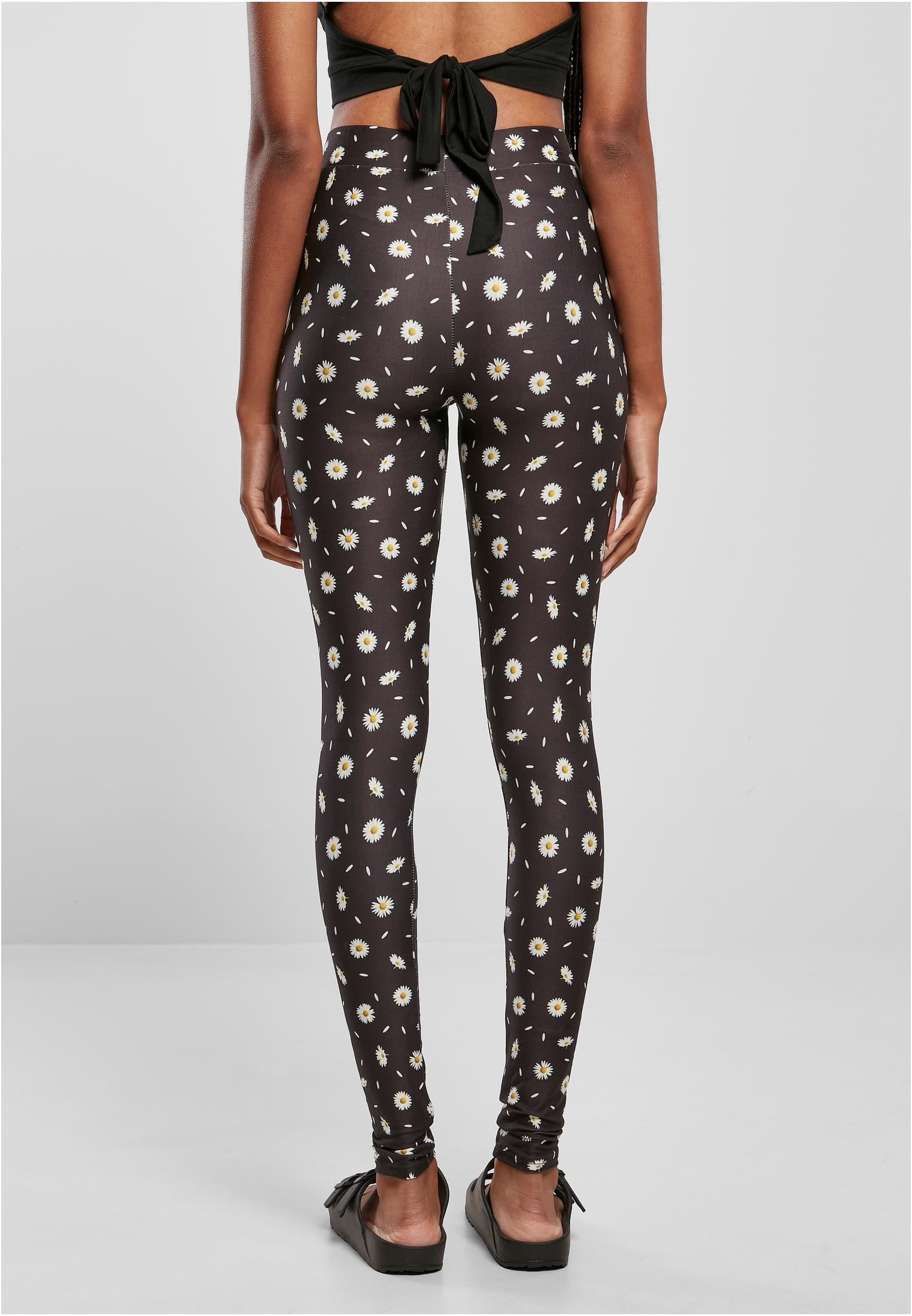 Vy bakifrån på en kvinna som bär svarta leggings med ett heltäckande mönster av prästkragar.