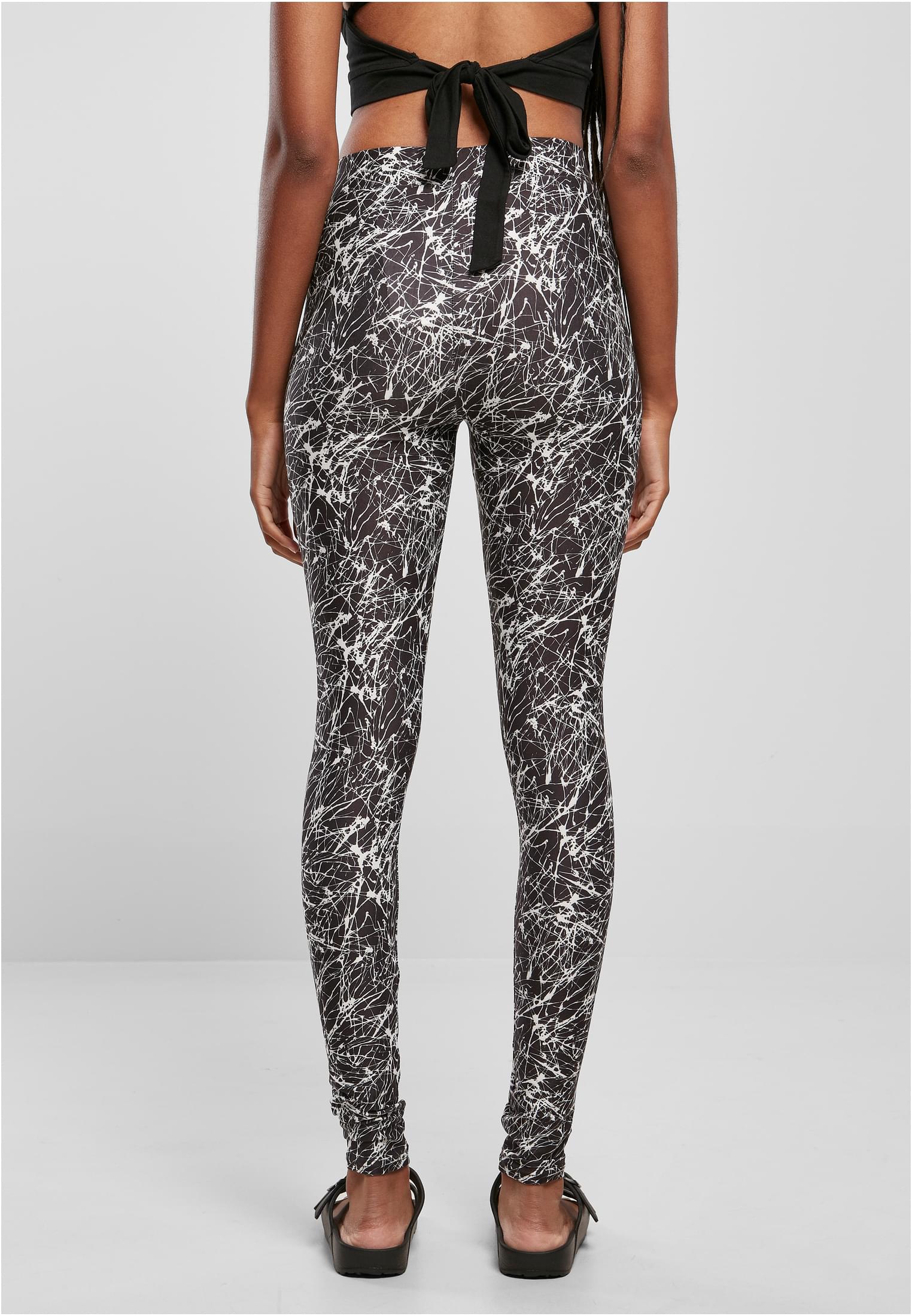 Baksidan av en modell som bär svarta leggings med ett vitt stänkmönster.