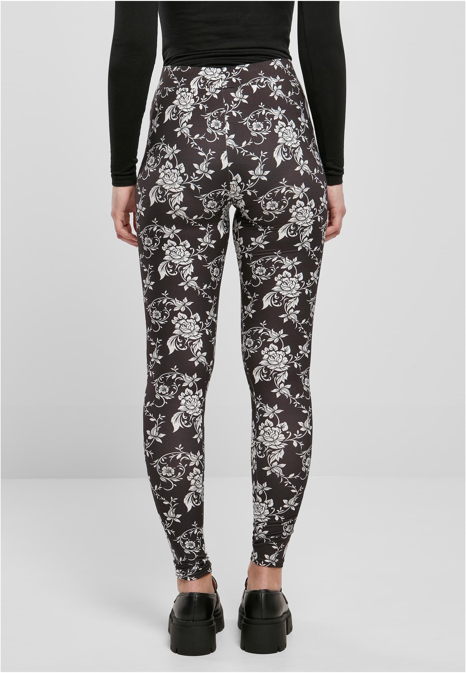 Kvinna sedd bakifrån, klädd i svarta leggings med ett heltäckande vitt blommönster.