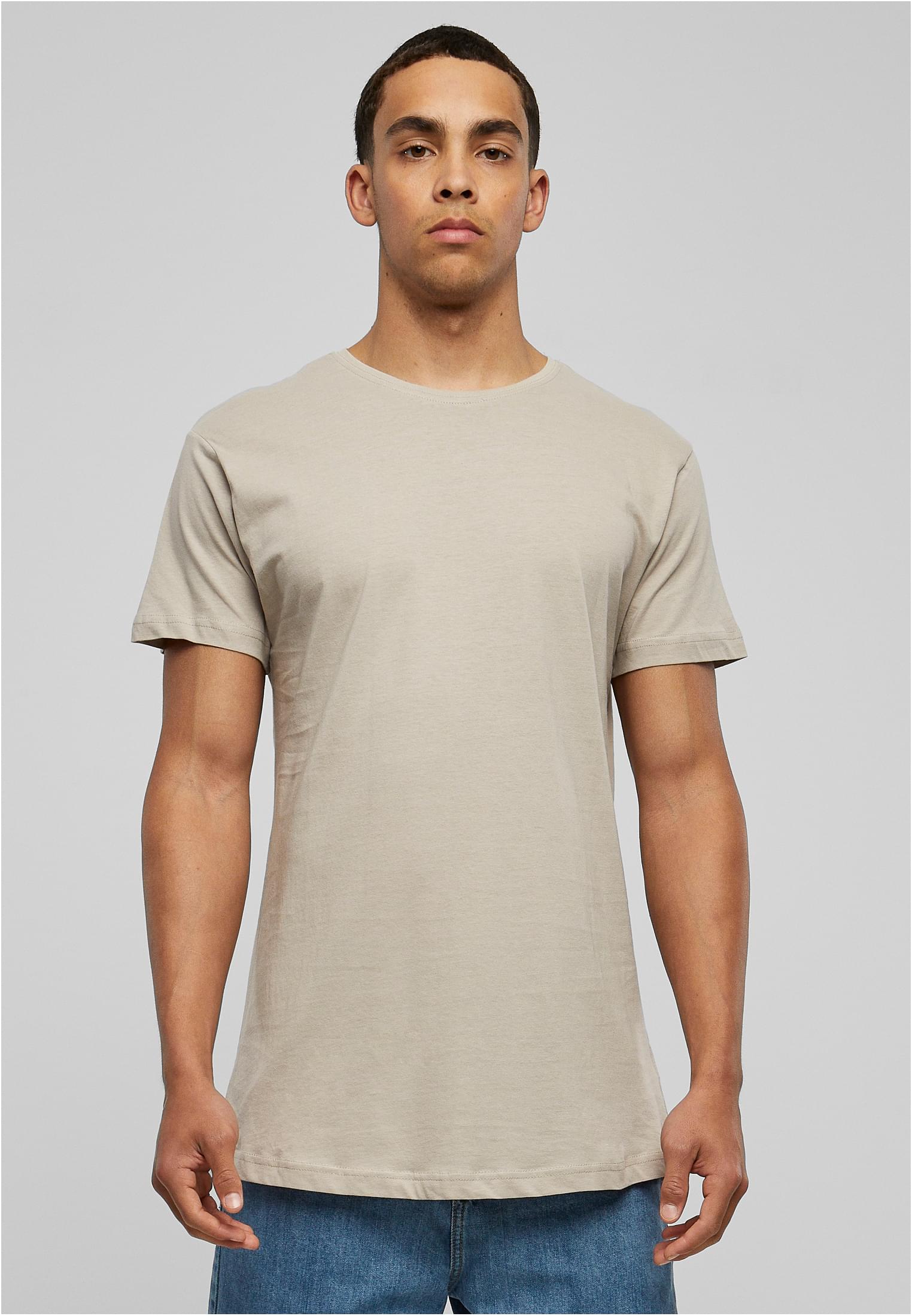 Frontvy av en manlig modell som bär en terrakottafärgad UC Shaped Long Tee mot en ljusgrå bakgrund.