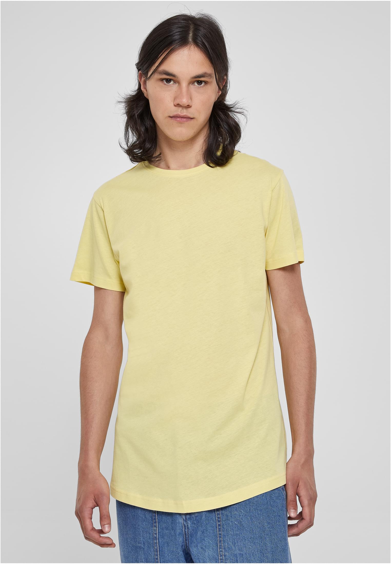Manlig modell som bär en ljusgul UC Shaped Long Tee med rundad nederkant, sedd framifrån.