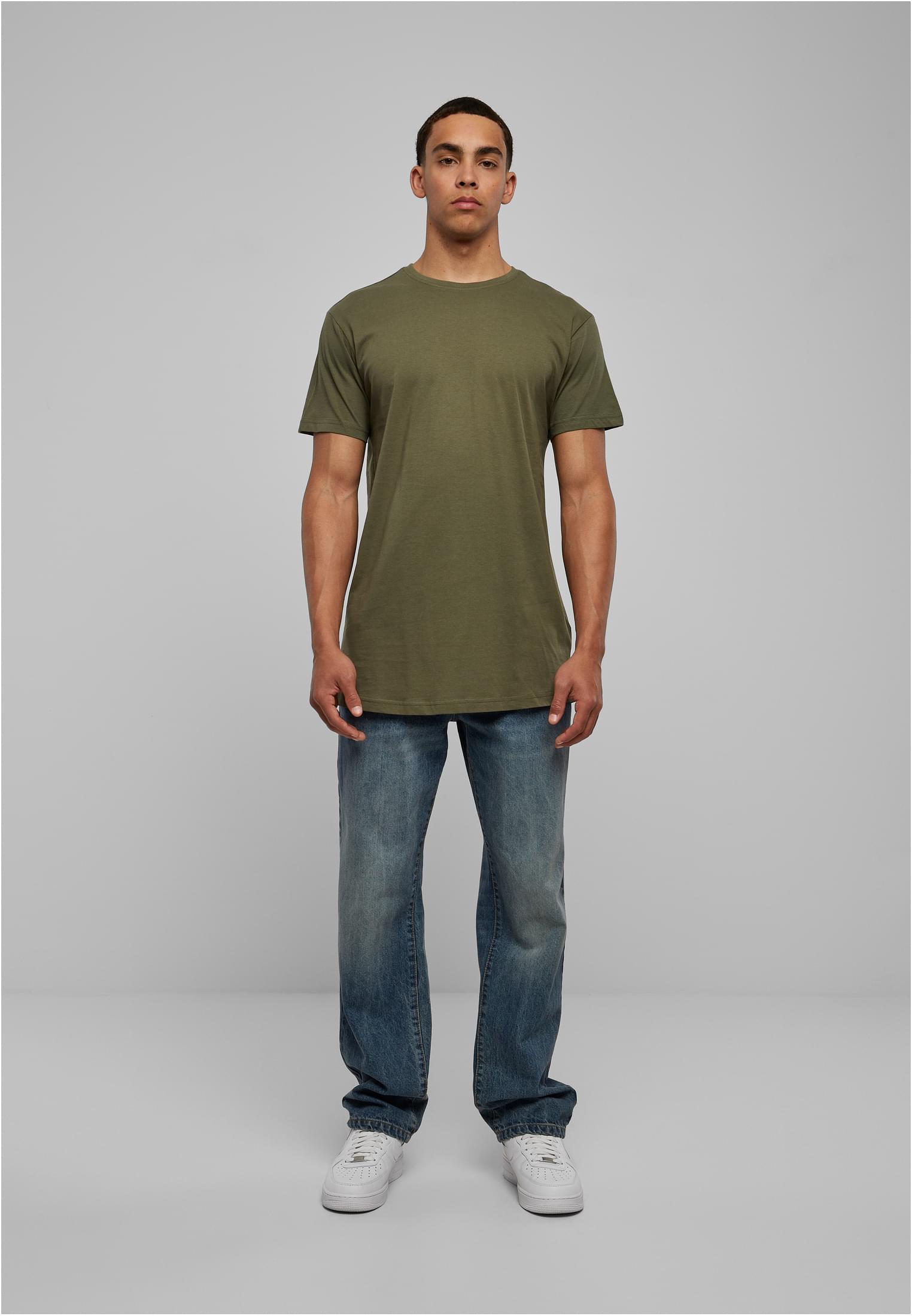 En manlig modell sedd framifrån, klädd i en olivgrön Shaped Long Tee, blåa jeans och vita sneakers.