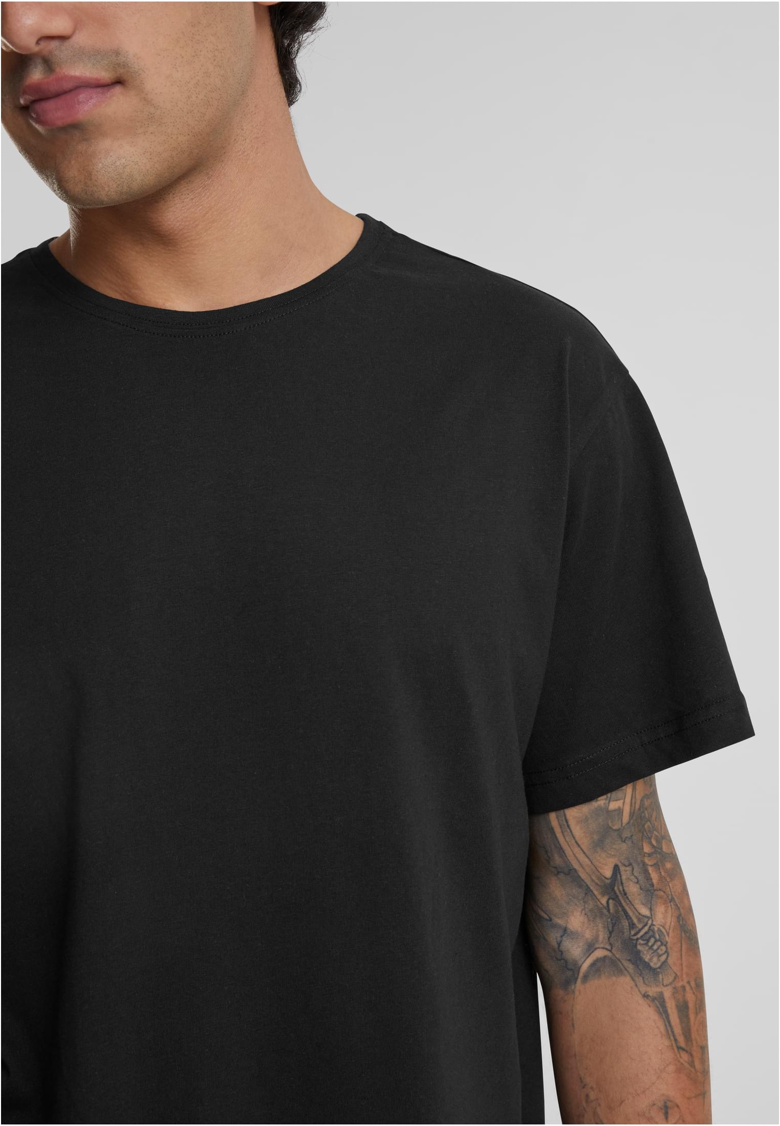 Närbild på en man med en tatuerad arm som bär en svart Shaped Long Tee.