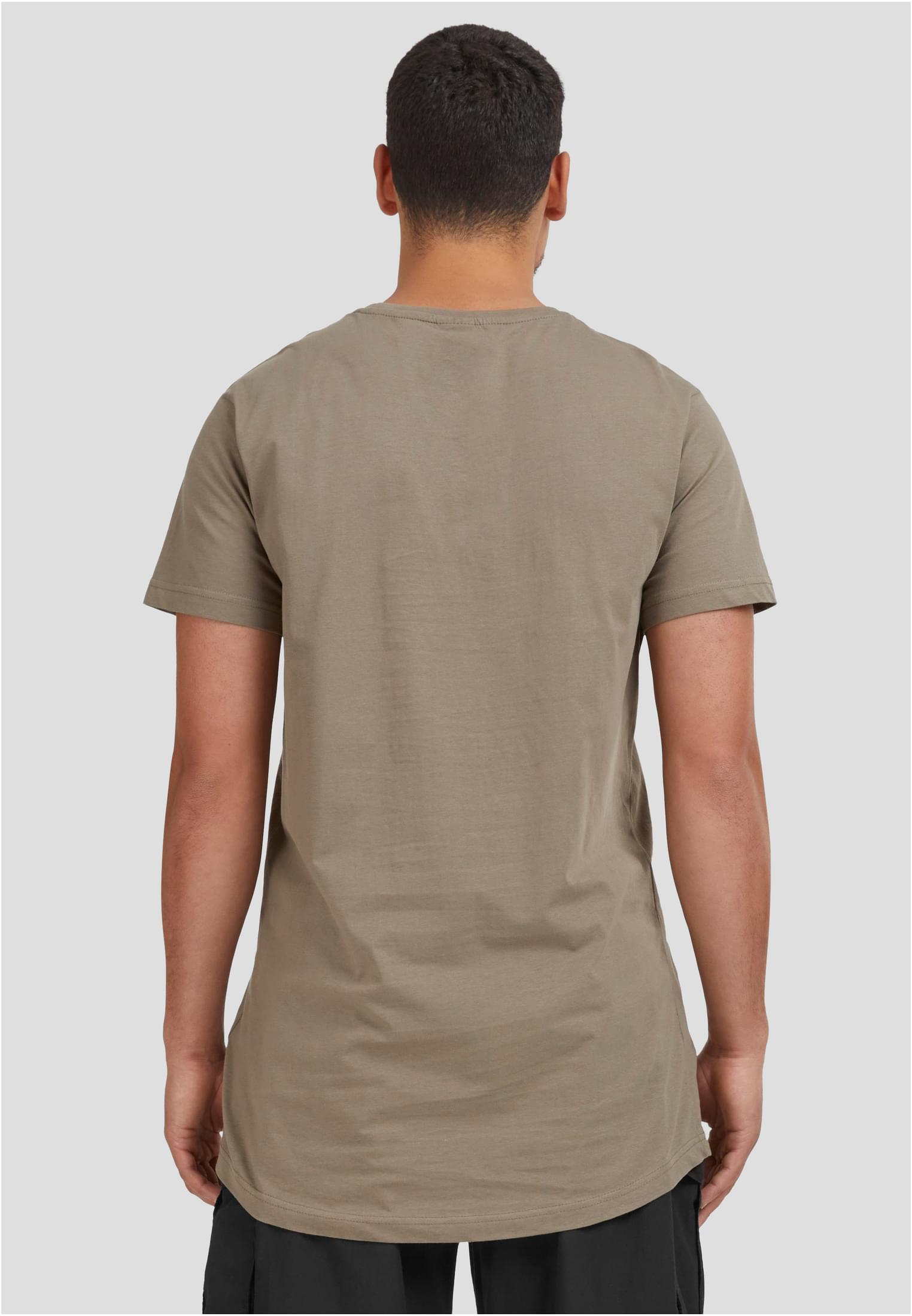 Baksidan av en man som bär en terrakottafärgad UC Shaped Long Tee med längre passform och rundad fåll.