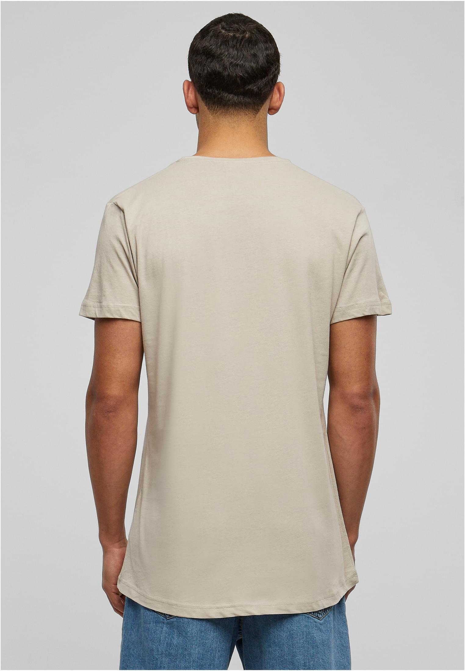 En man sedd bakifrån som bär en terrakottafärgad UC Shaped Long Tee, vilket visar t-shirtens passform och rundade fåll.