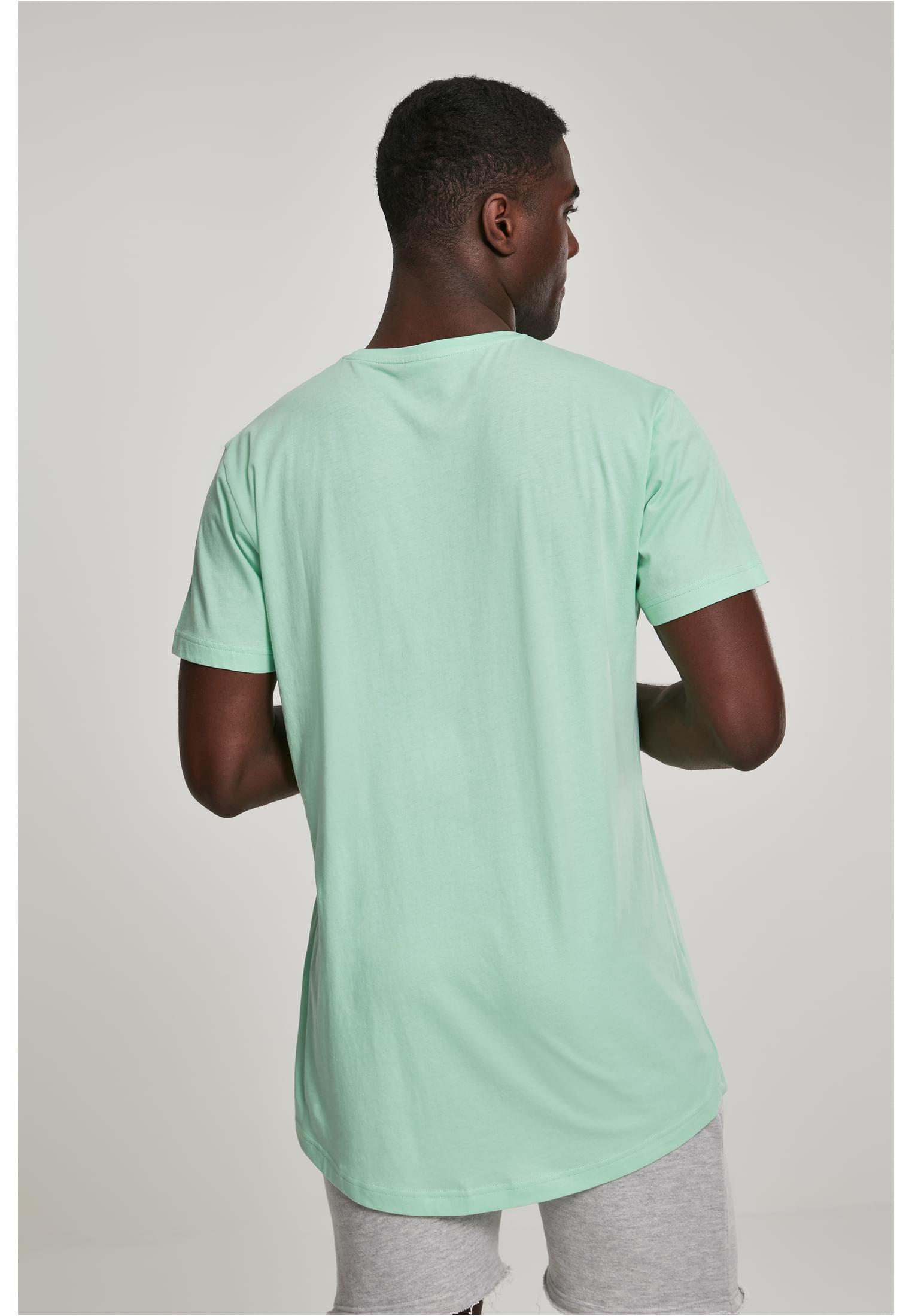 Man sedd bakifrån som visar den längre passformen och rundade fållen på en mintgrön UC Shaped Long Tee.