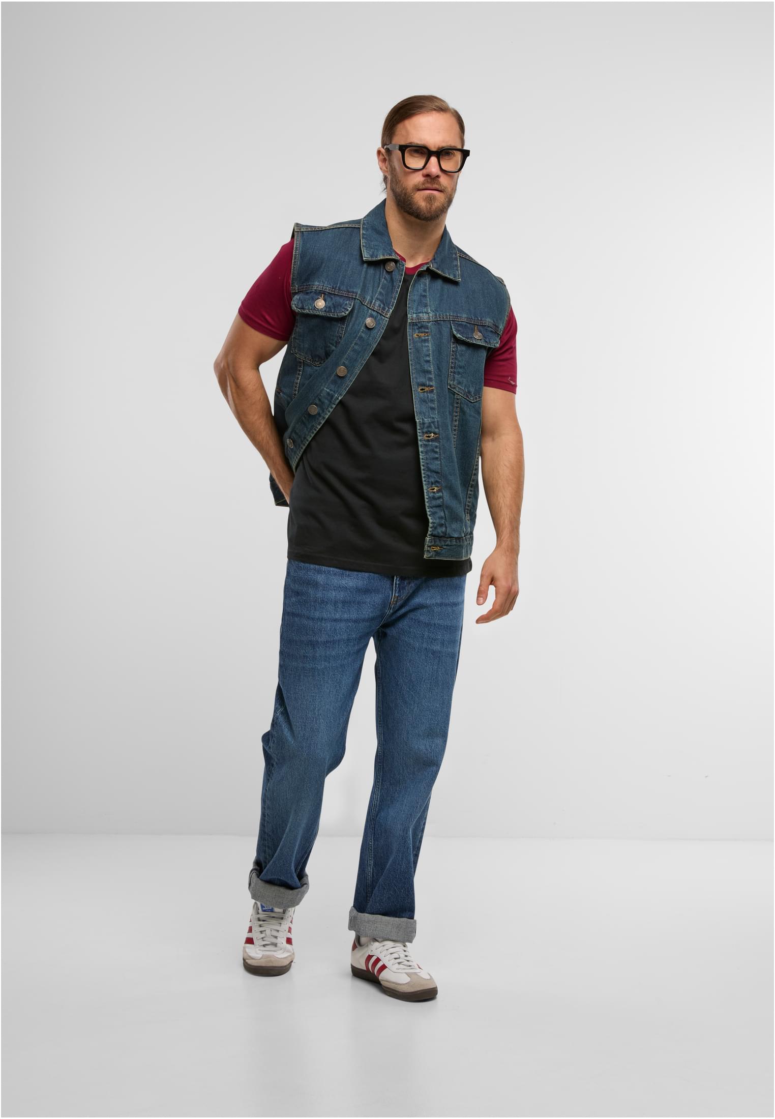 Helkroppsbild på en man som bär en Raglan Contrast Tee, stylad med en öppen jeansväst, blå jeans och sneakers.