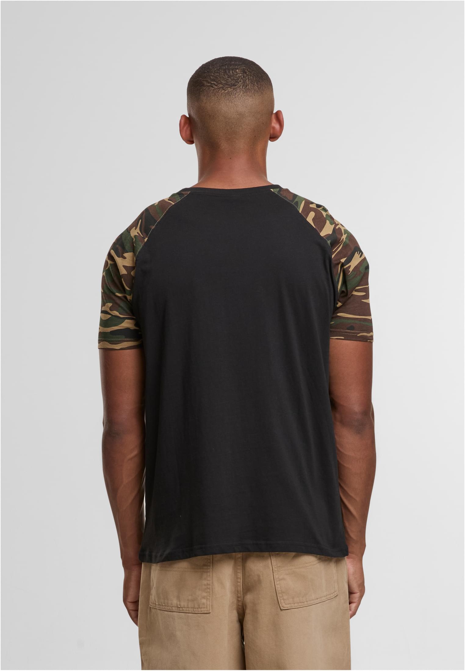 Baksidan av en man som bär en svart Raglan Contrast T-shirt med kamouflagemönstrade ärmar.