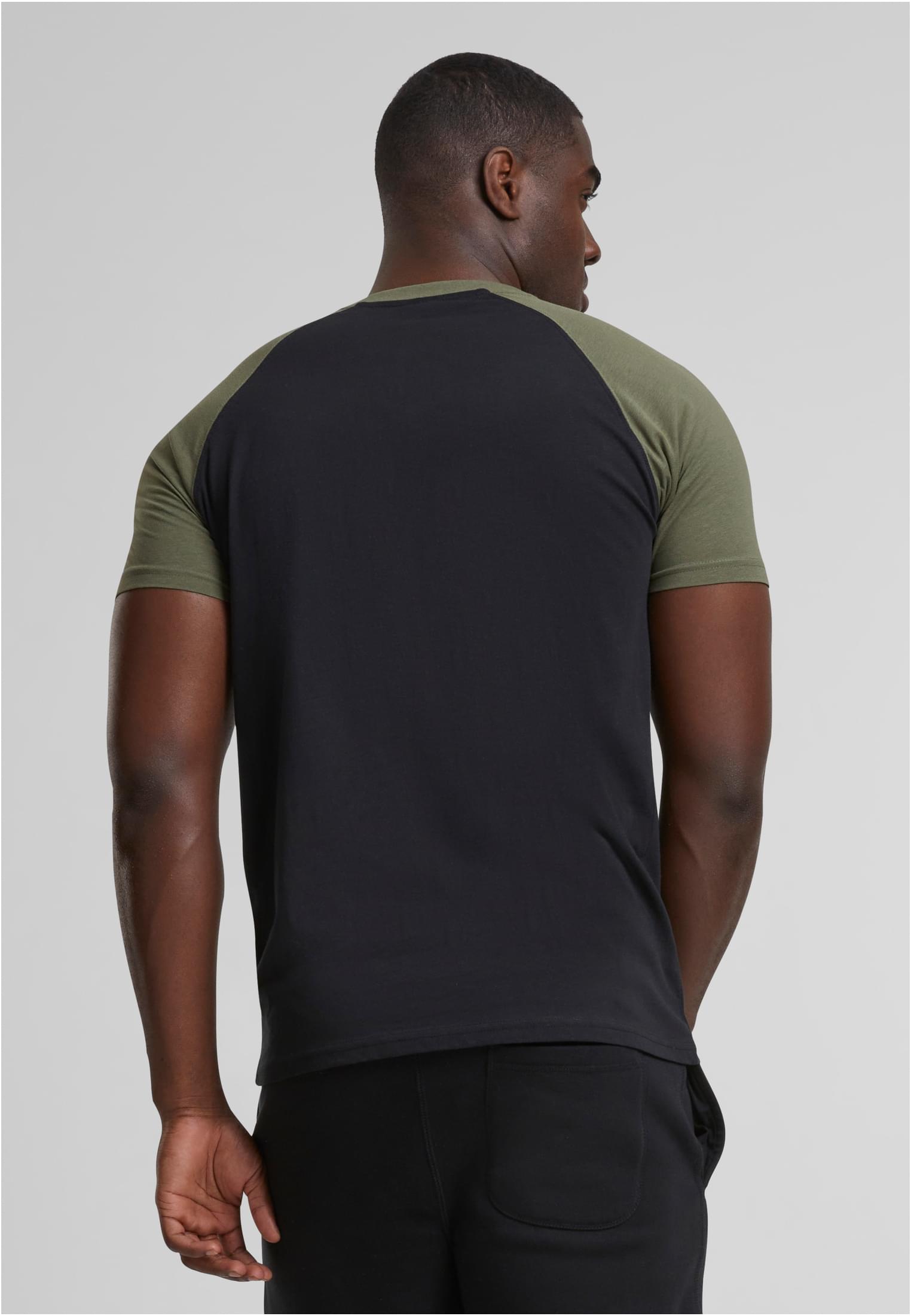 En man fotograferad bakifrån som bär en svart Raglan Contrast Tee med olivgröna ärmar.