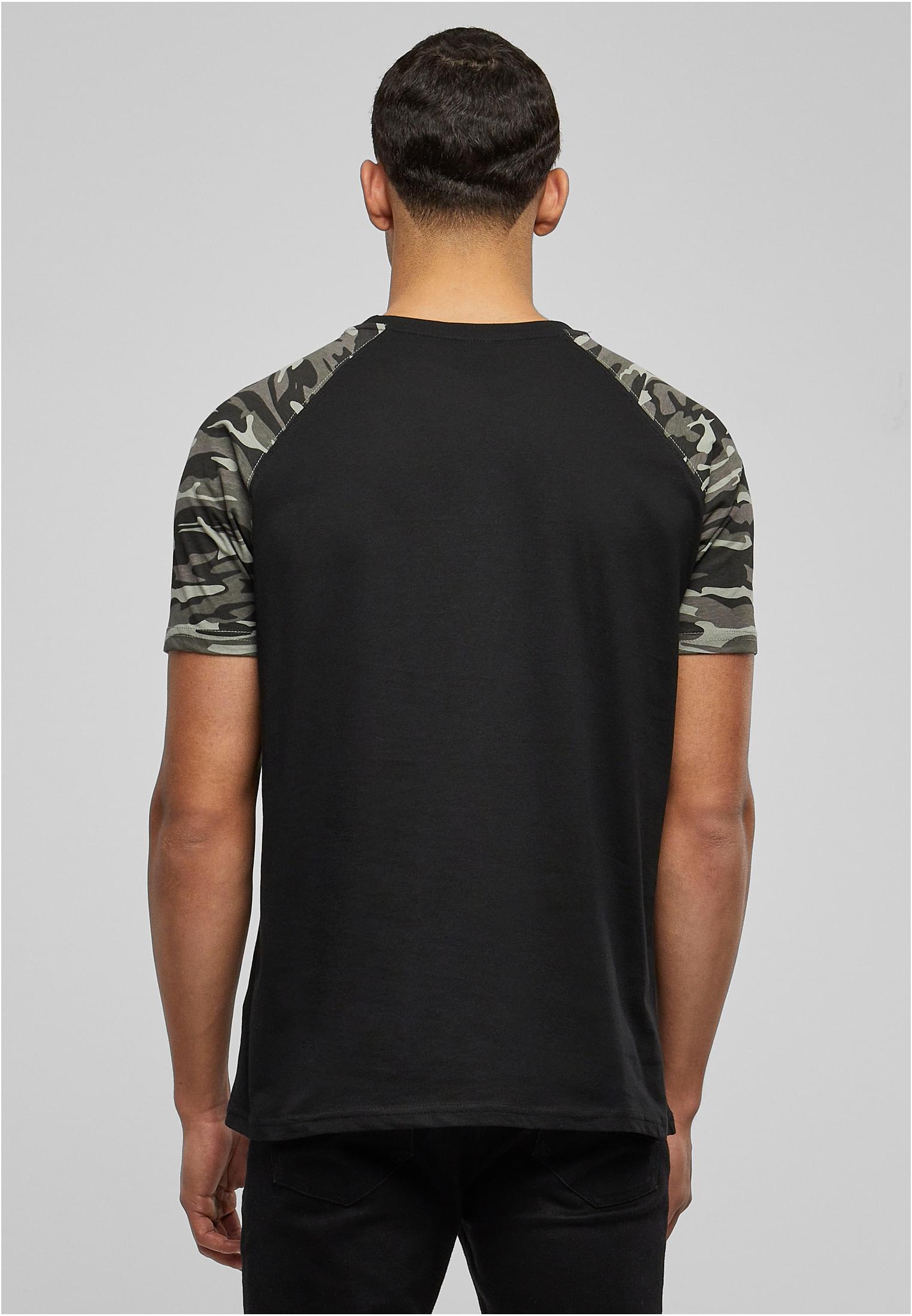 Vy bakifrån av en man som bär en svart raglan-t-shirt med korta, kamouflagemönstrade ärmar.