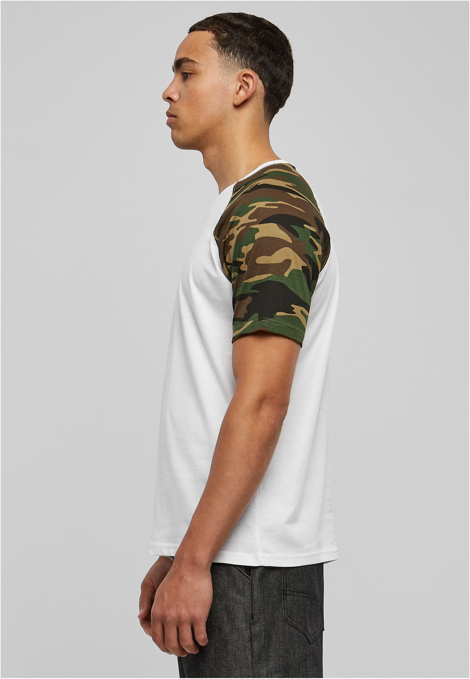 Man sedd från sidan i en vit t-shirt med kamouflagemönstrade raglanärmar.