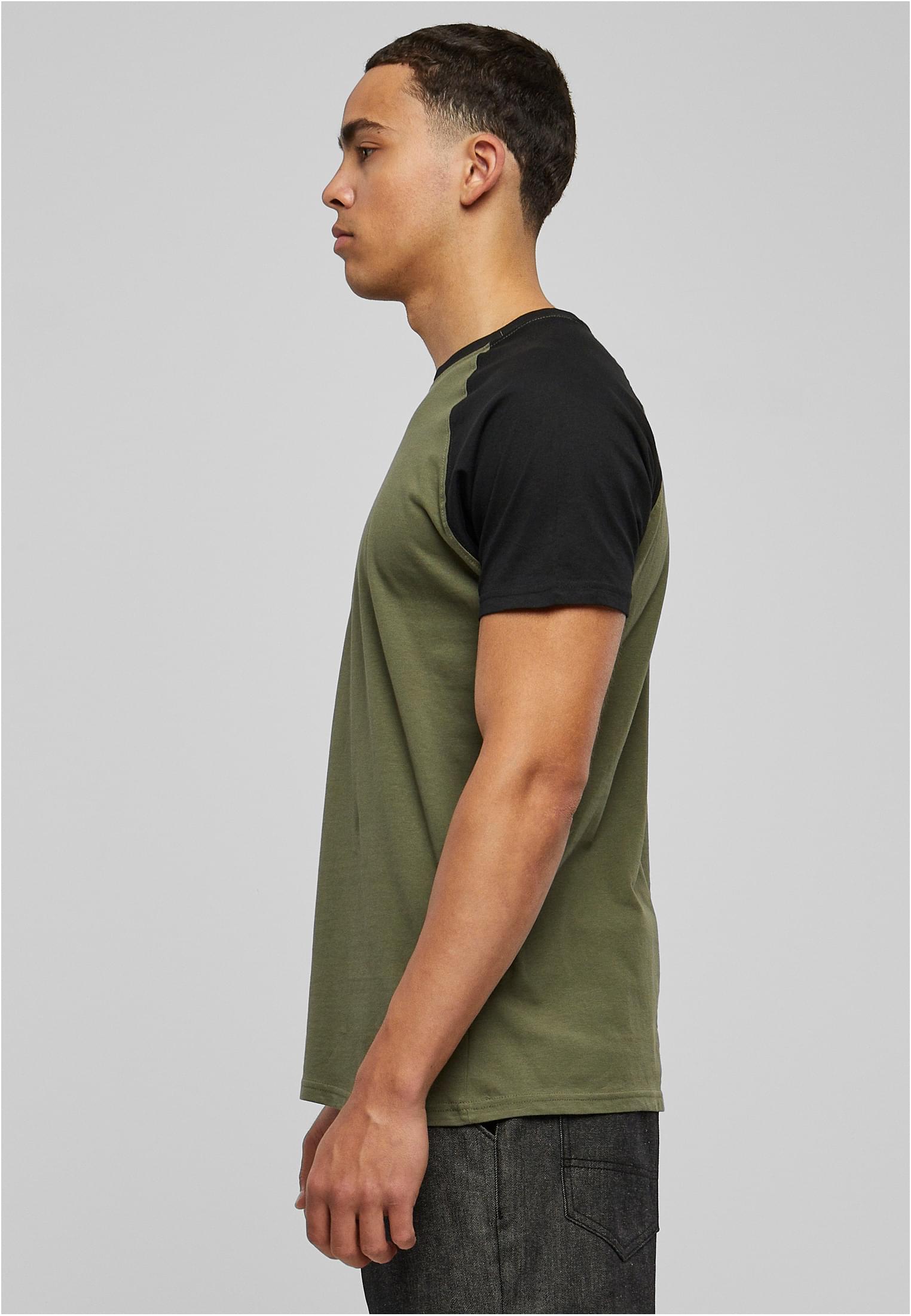 Man i profil som bär en olivgrön raglan-t-shirt med svarta ärmar.