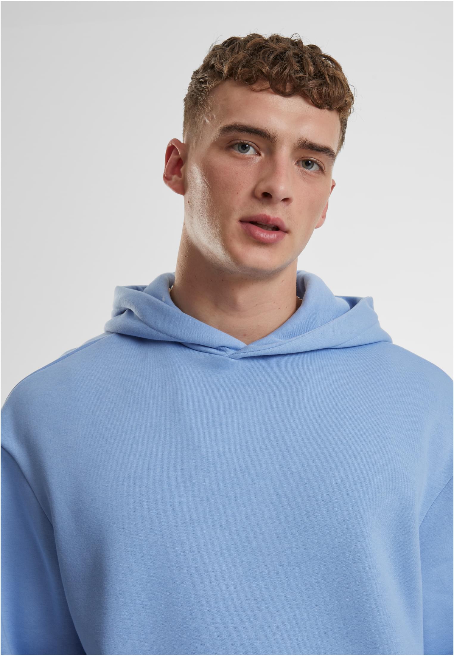 Närbild på en man som bär en ljusblå hoodie.