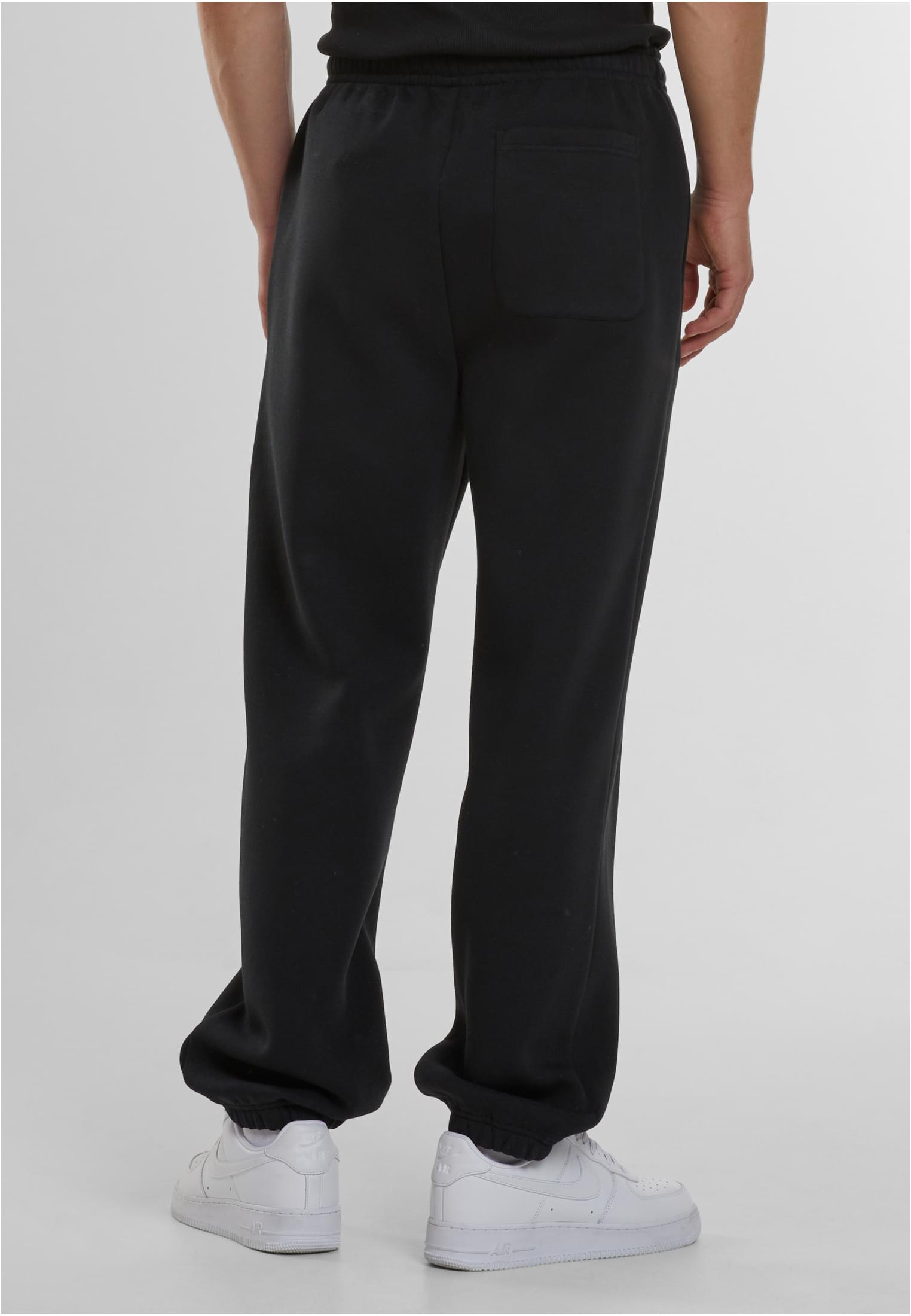 Baksidan av en man som bär svarta Fluffy Sweatpants och vita sneakers.