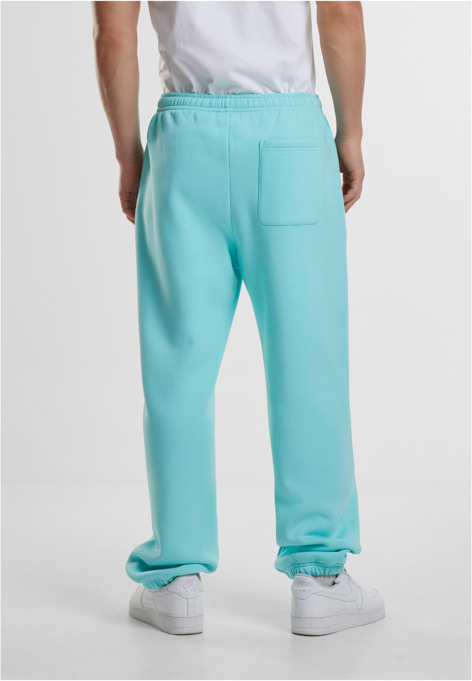 En man sedd bakifrån, klädd i ett par ljusblå Fluffy Sweatpants, en vit t-shirt och vita sneakers.