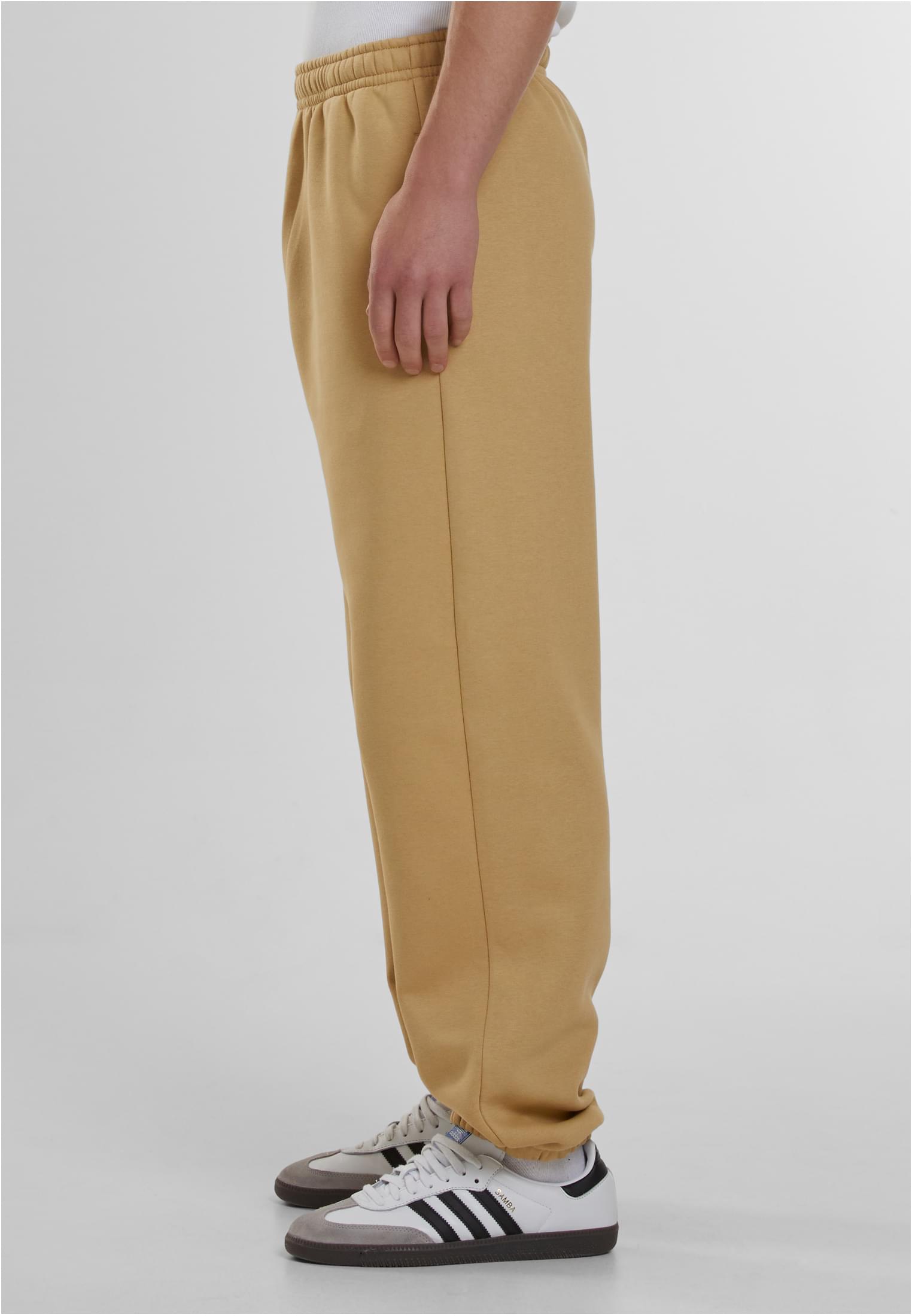 Sidovy av en man som bär beigefärgade Fluffy Sweatpants.