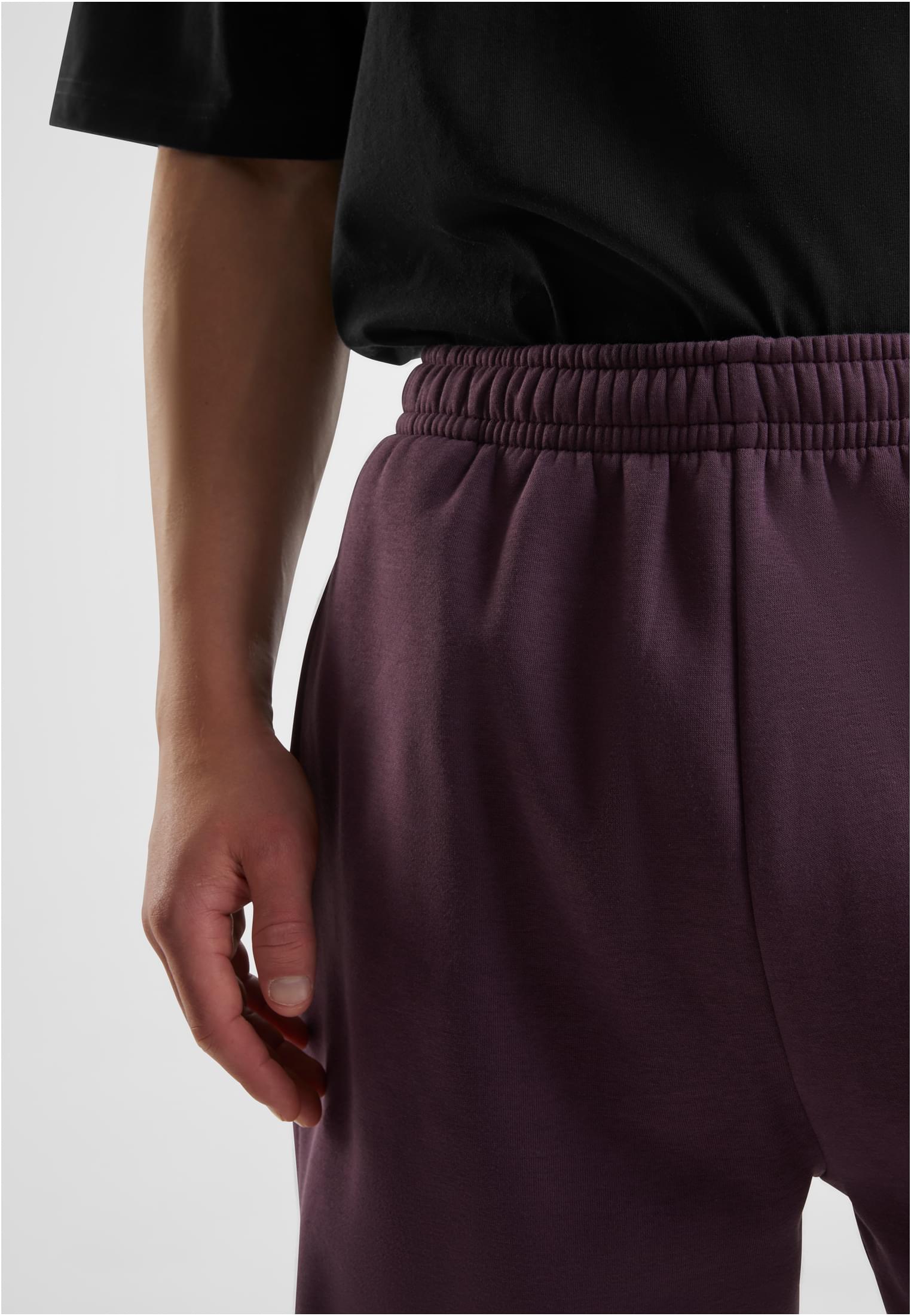 Detaljbild på en man som bär plommonlila Fluffy Sweatpants.