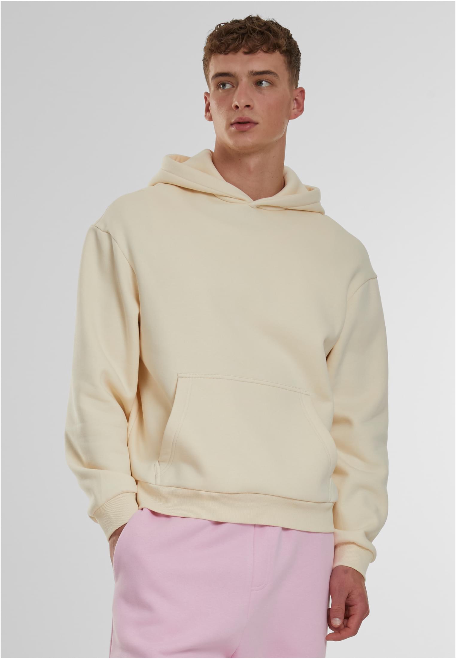 Framsida av en manlig modell som bär en ljusbeige Fluffy Hoody.